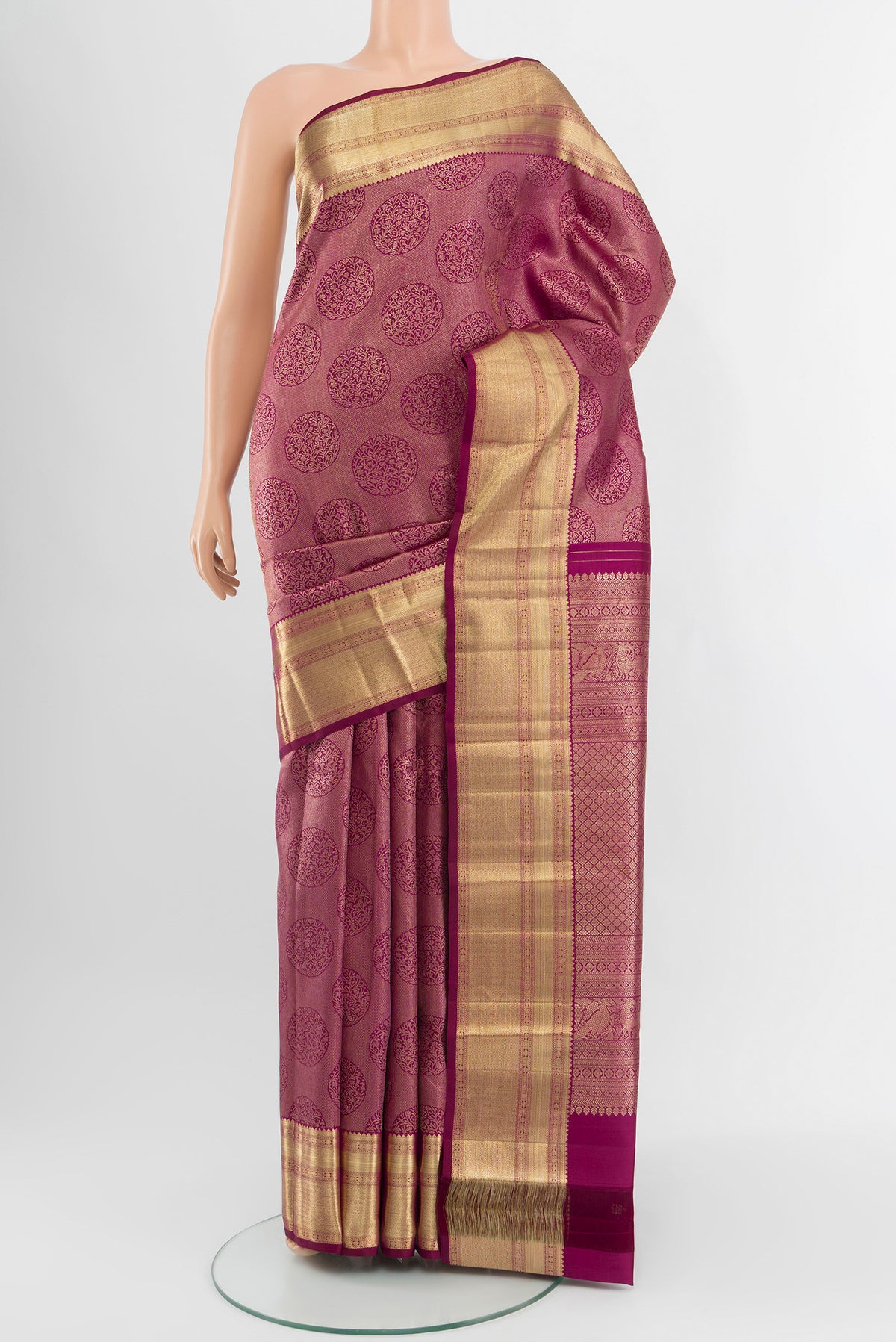 Magenta Kanchipuram Silk Saree with Zari Brocade on the body and Zari Border.  displayed on a mannequin