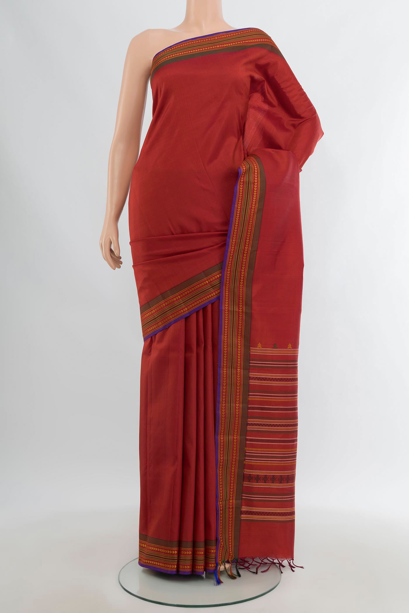 Rust Kanchipuram Silk Saree with Plain Body and Thread Border.  displayed on a mannequin
