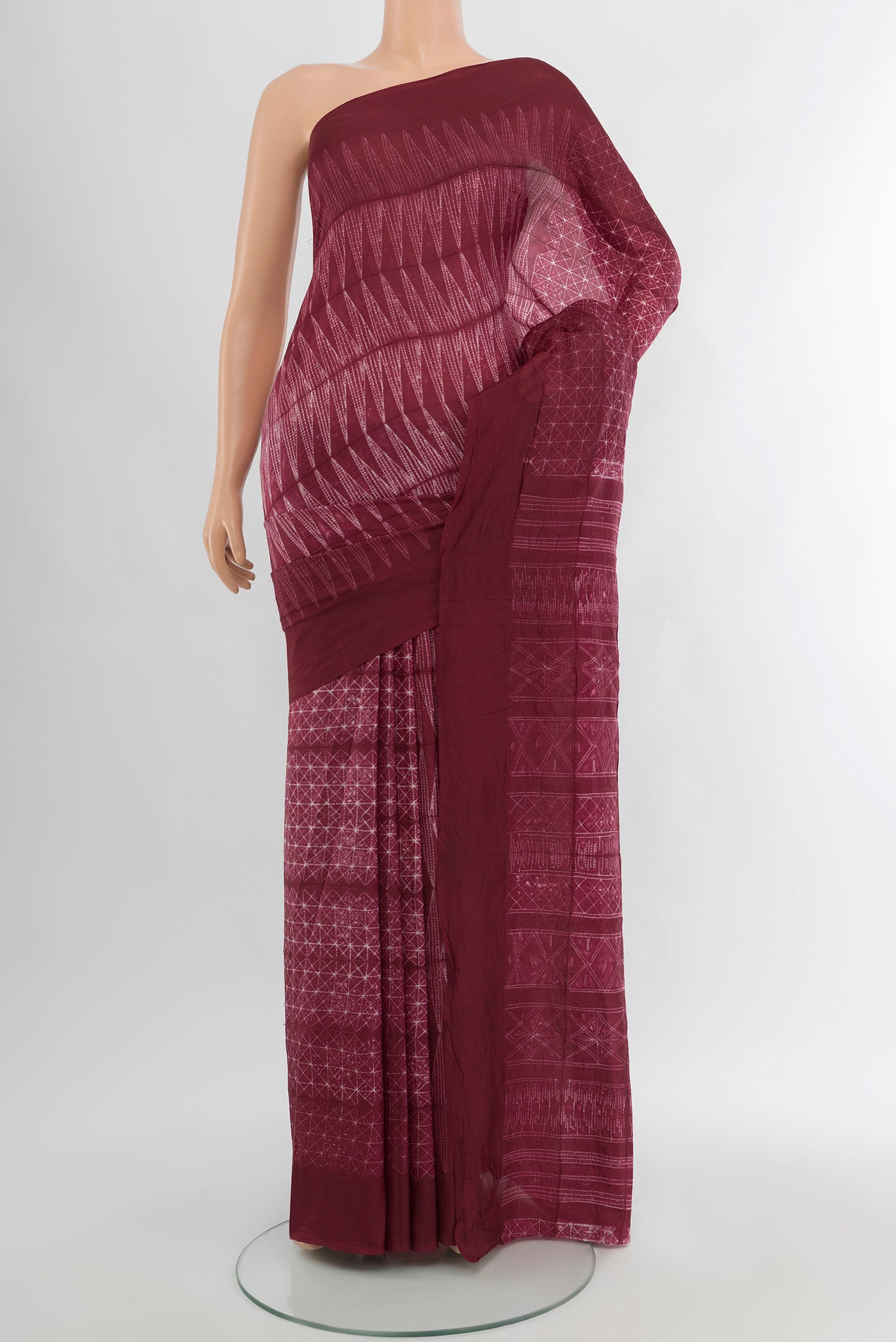 Maroon Tussar Silk Saree with Floral Print on the body and Plain Border.  displayed on a mannequin