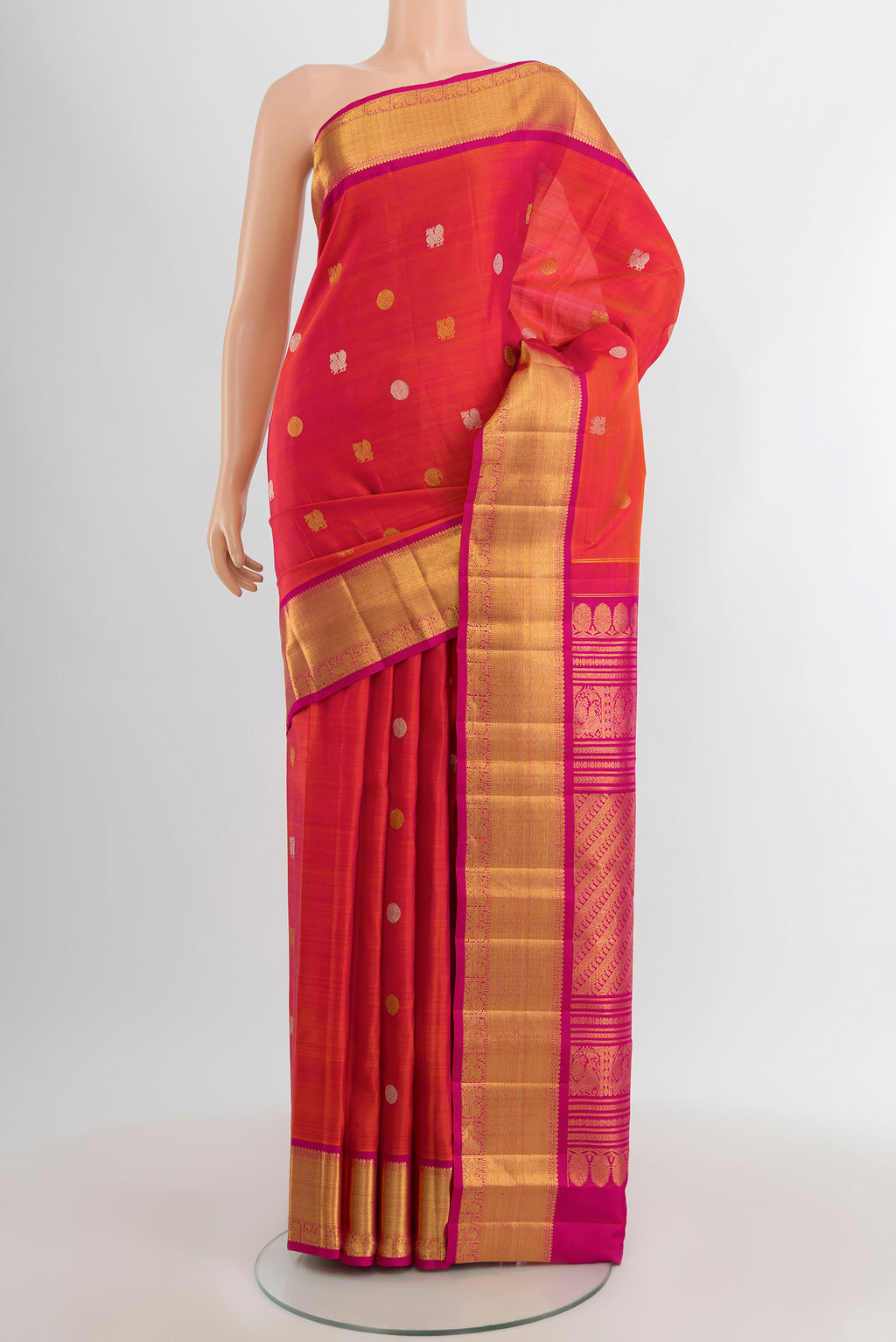 Coral Kanjivaram Silk Saree with Zari Butta on the body and Zari Border.  displayed on a mannequin