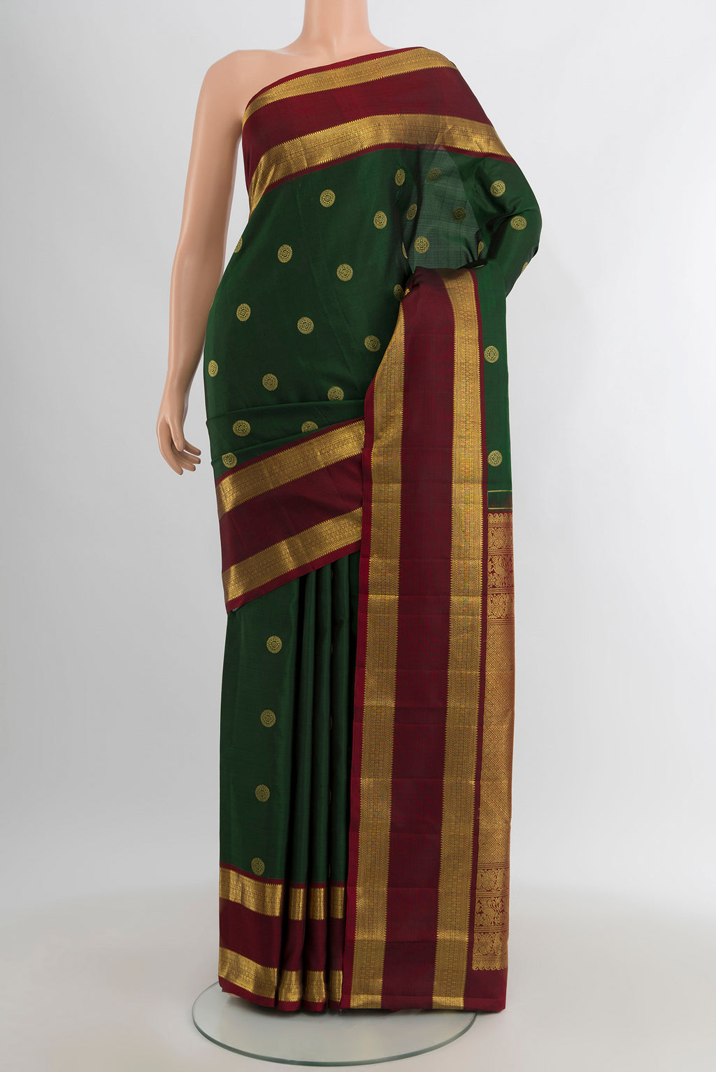 Bottle Green Kanjivaram Silk Saree with Zari Butta on the body and Zari Border.  displayed on a mannequin