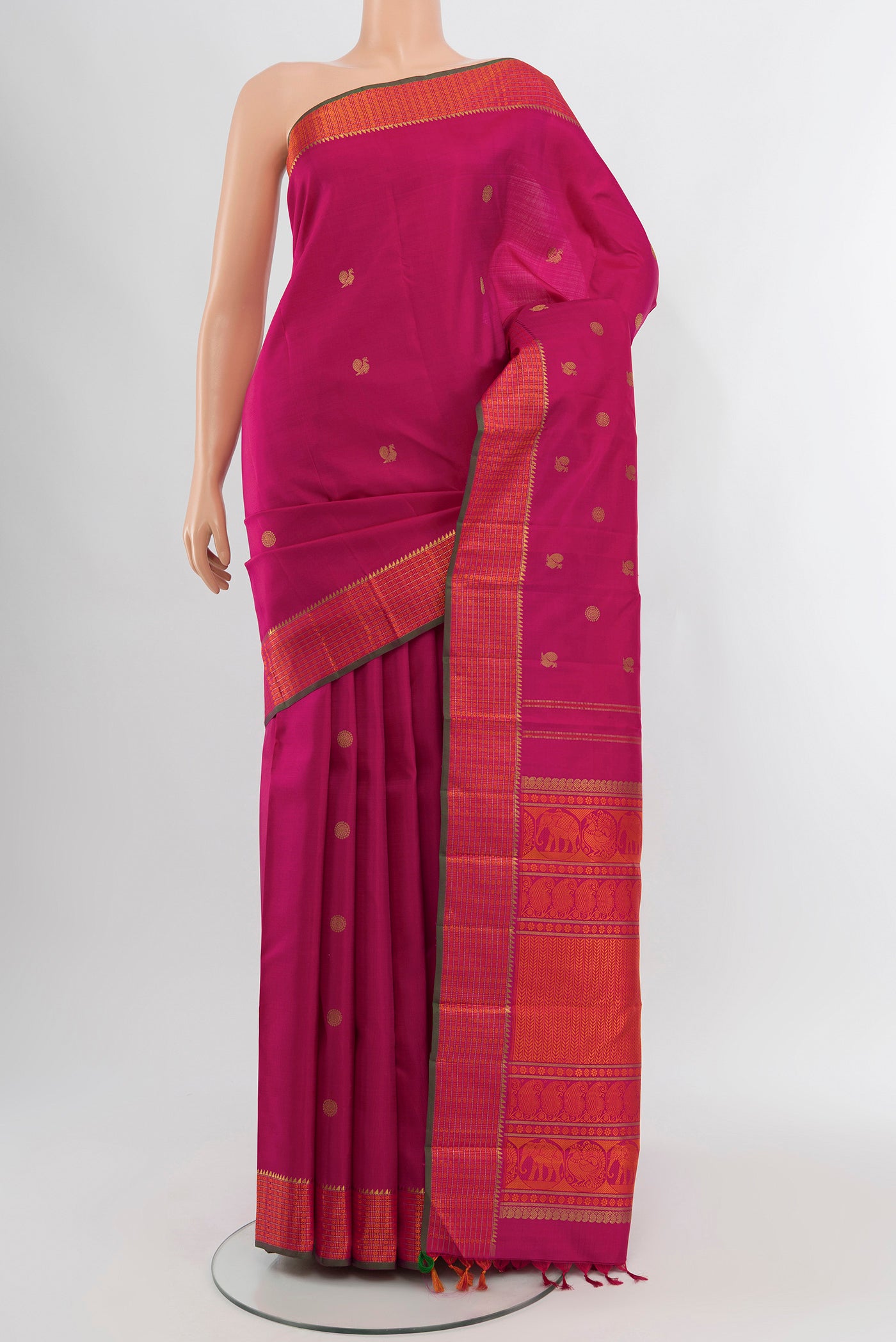 Pure Silk Pure Zari Rani Pink Kanchipuram Saree with Zari Butta on the body and Zari And Thread Border.  displayed on a mannequin