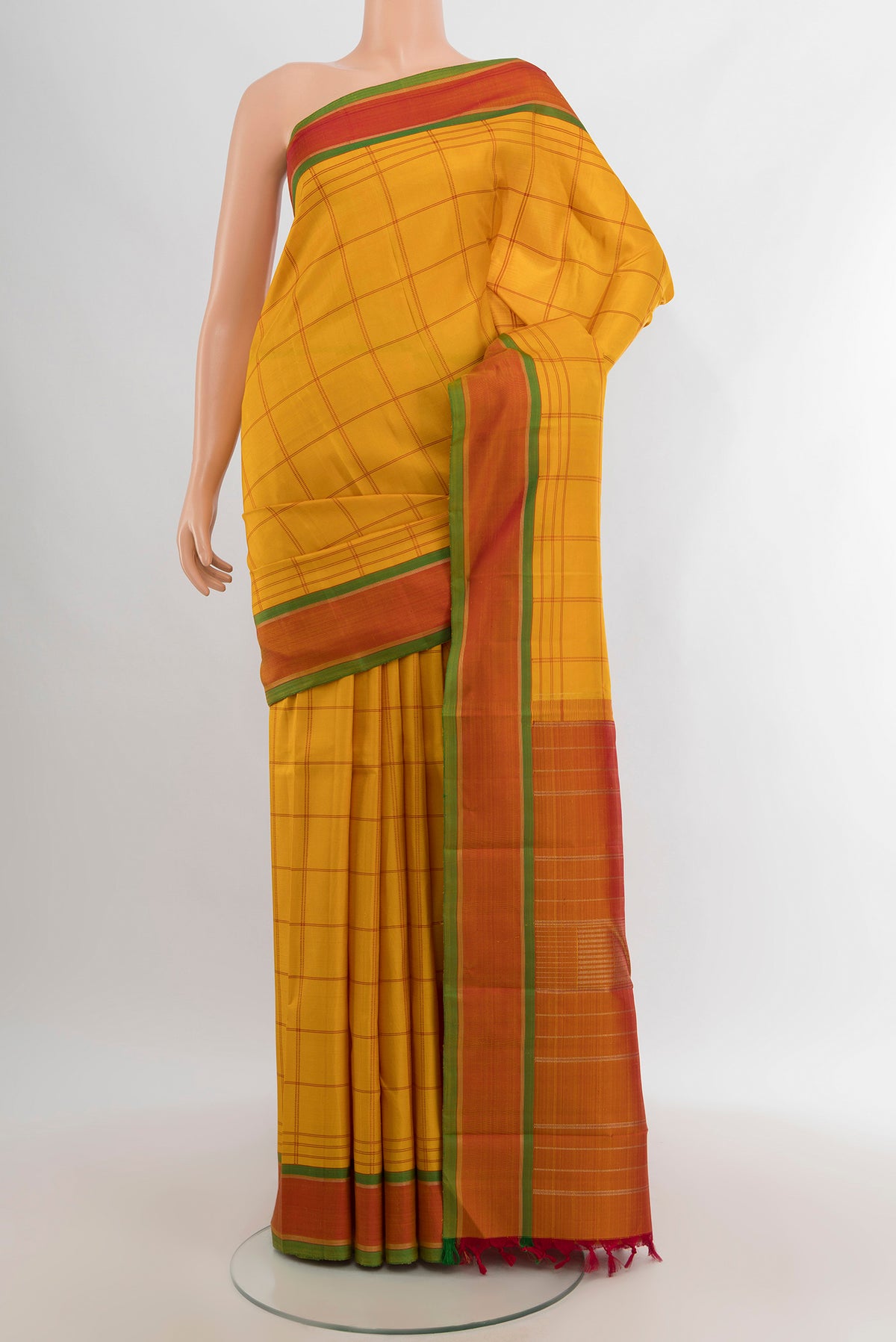 Mustard Kanjivaram Silk Saree with Checked design on the body and Plain Border.  displayed on a mannequin