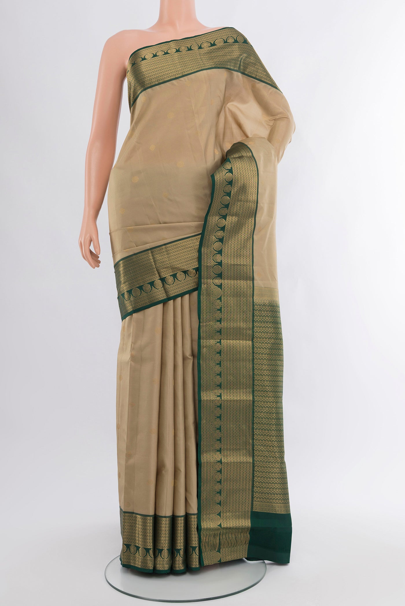 Beige Kanchipuram Silk Saree with Zari Butta on the body and Zari Border.  displayed on a mannequin