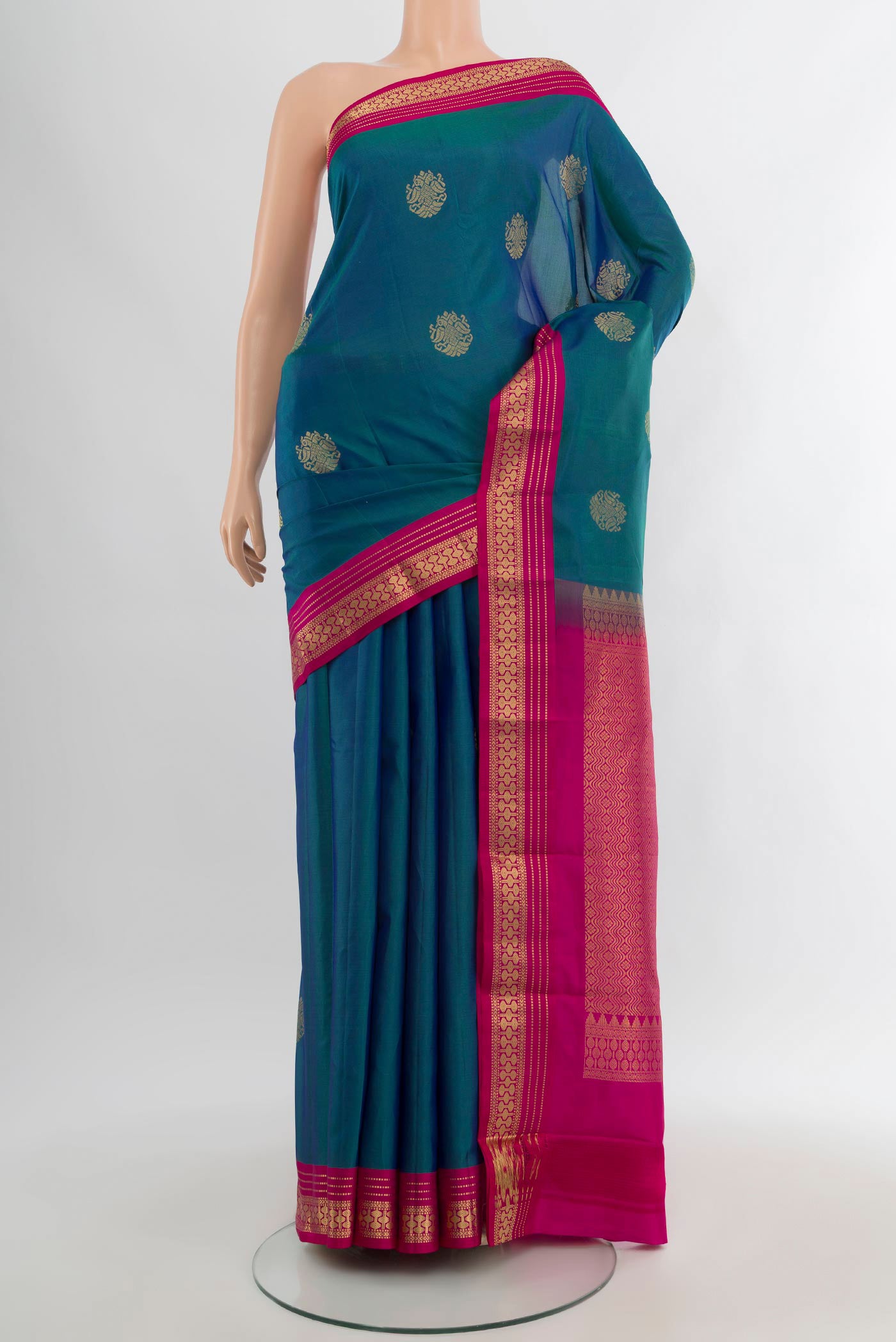 Peacock Blue Kanchipuram Silk Saree with Zari Butta on the body and Zari Border.  displayed on a mannequin