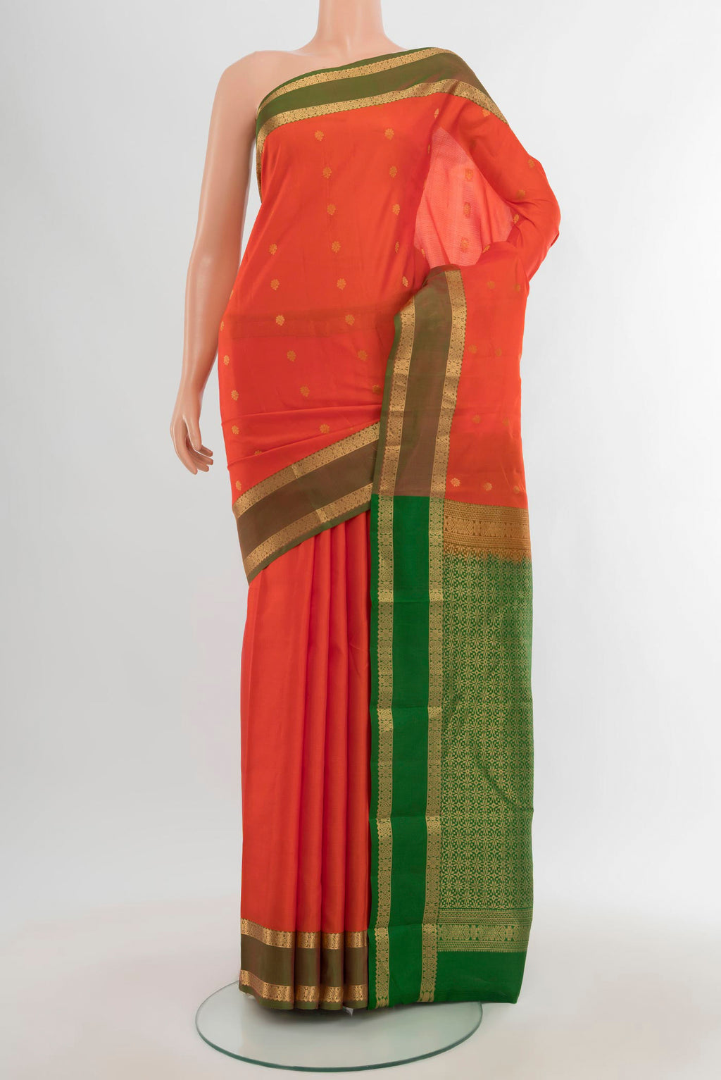Orange Kanjivaram Silk Saree with Zari Butta on the body and Zari Border.  displayed on a mannequin