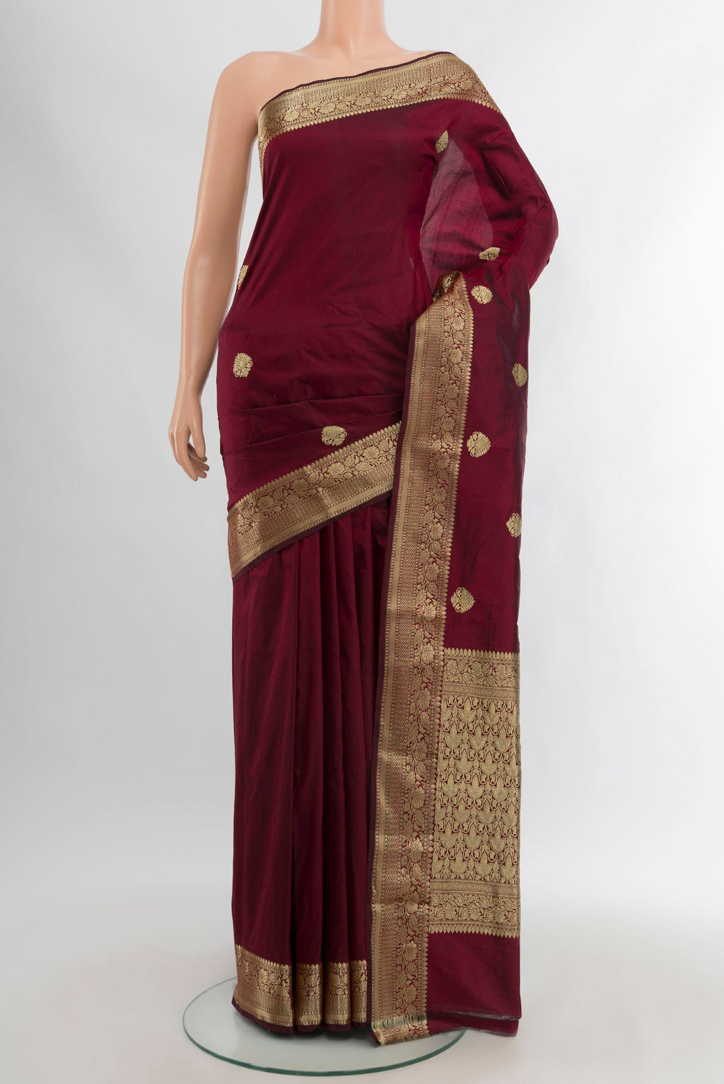 Maroon Banarasi Katan Silk Saree with Zari Butta on the body and Zari Border.  displayed on a mannequin