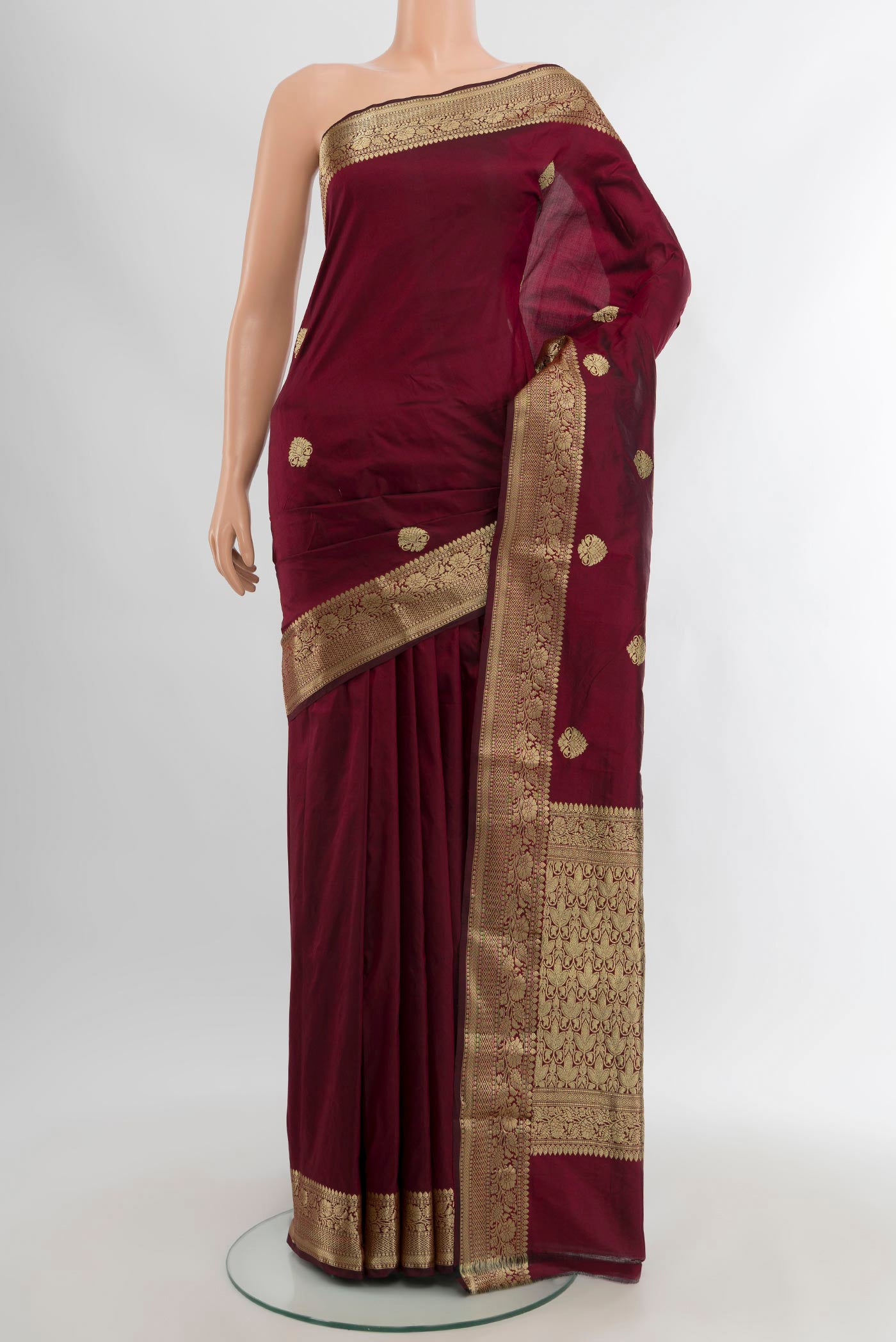 Maroon Banarasi Katan Silk Saree with Zari Butta on the body and Zari Border.  displayed on a mannequin