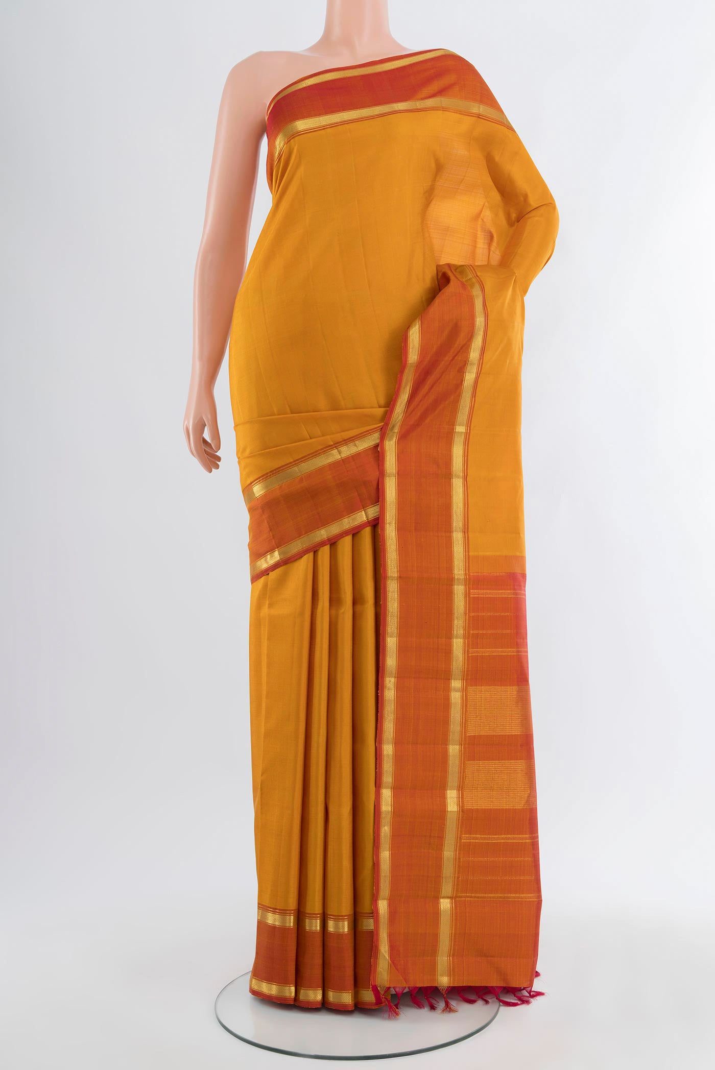 Mustard Kanjivaram Silk Saree with Plain Body and Zari Border.  displayed on a mannequin