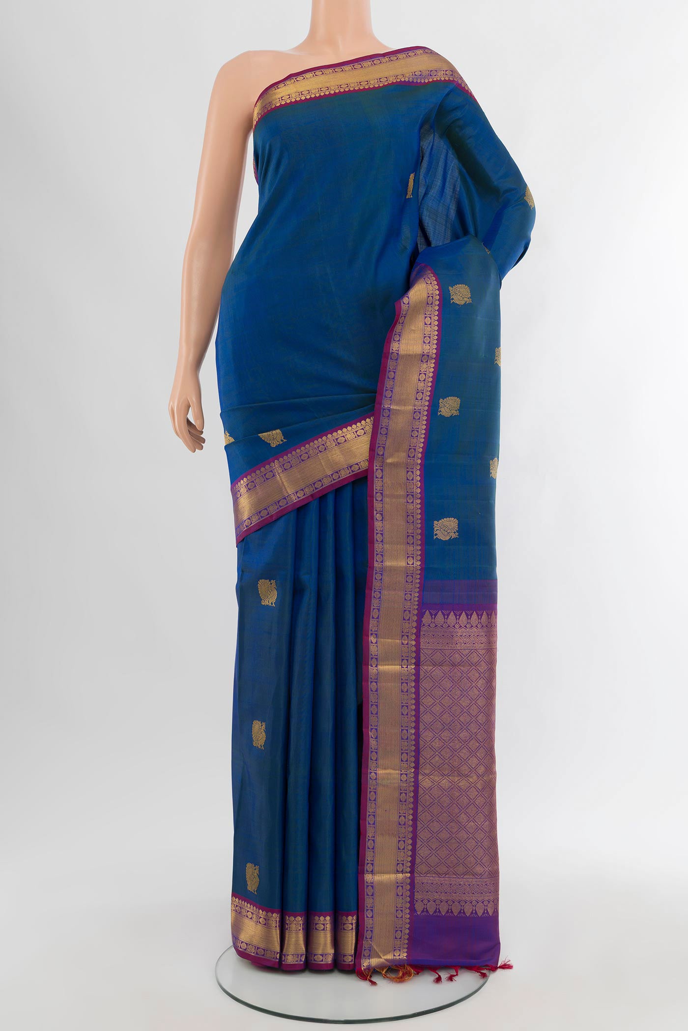 Peacock Blue Kanjivaram Silk Saree with Zari Butta on the body and Zari Border.  displayed on a mannequin