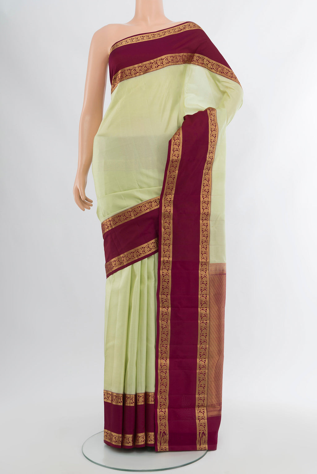 Pista Green Kanchipuram Silk Saree with Plain Body and Zari Border.  displayed on a mannequin