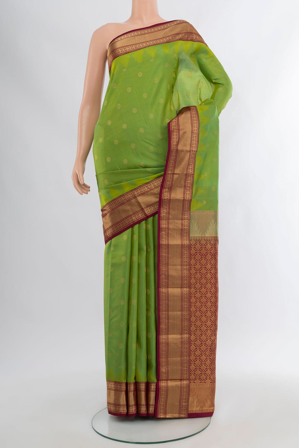 Green Kanchipuram Silk Saree with Zari Butta on the body and Zari Border.  displayed on a mannequin