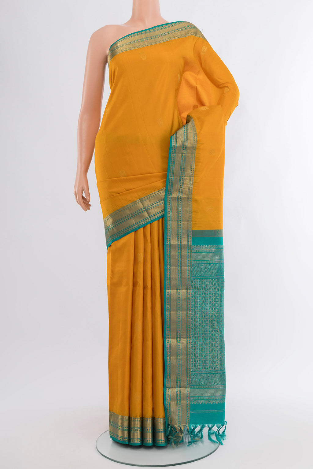 Mustard Kanjivaram Silk Saree with Zari Butta on the body and Zari Border.  displayed on a mannequin