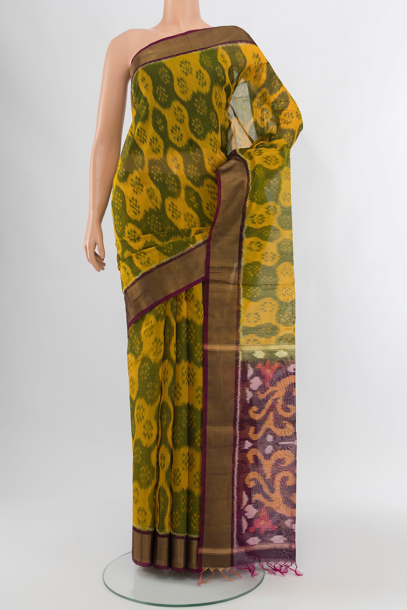 Yellow Silk Cotton Saree with Ikat Print on the body and Zari Border.  displayed on a mannequin