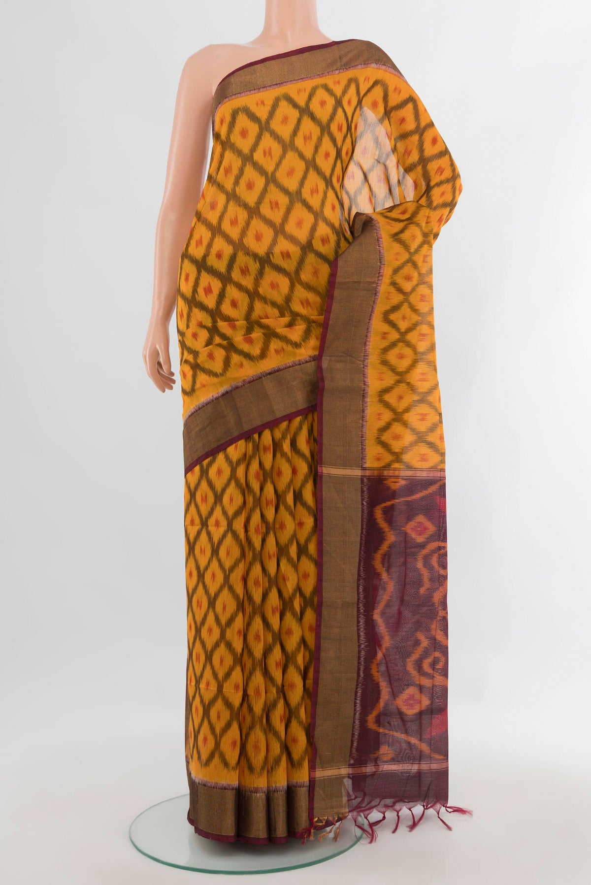 Yellow Silk Cotton Saree with Ikat design on the body and Zari Border.  displayed on a mannequin