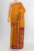 Mustard Kanchipuram Silk Saree with Zari Butta on the body and Zari Border.  displayed on a mannequin