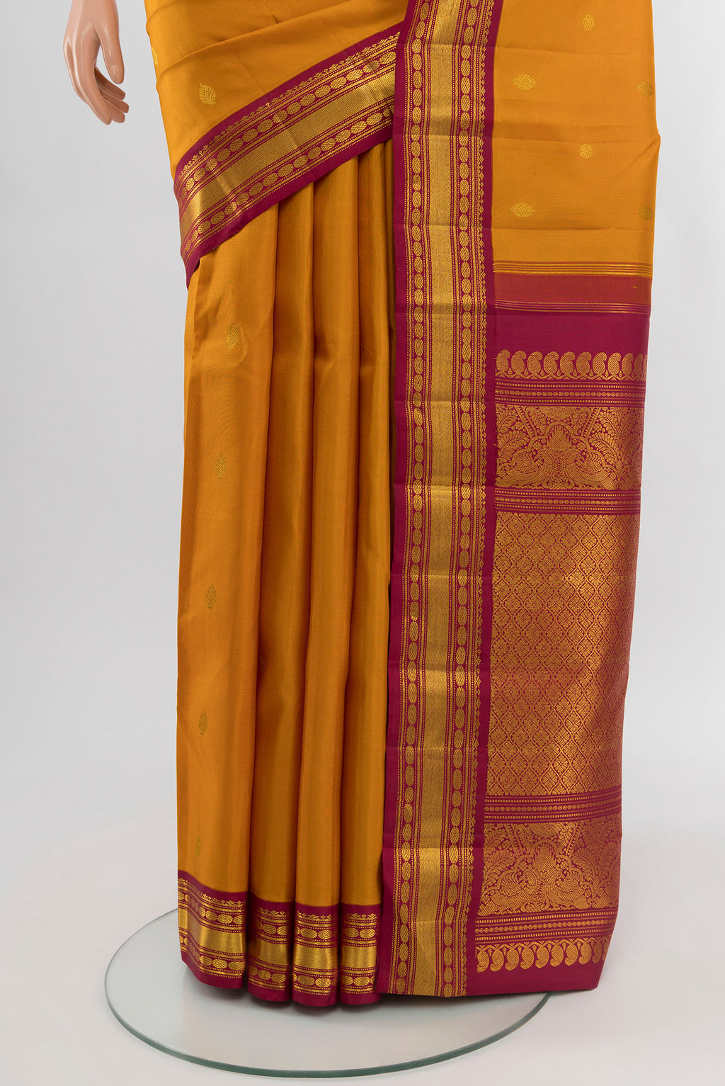 Pleats and pallu of Mustard Kanchipuram Silk Saree with Zari Butta on the body and Zari Border. 