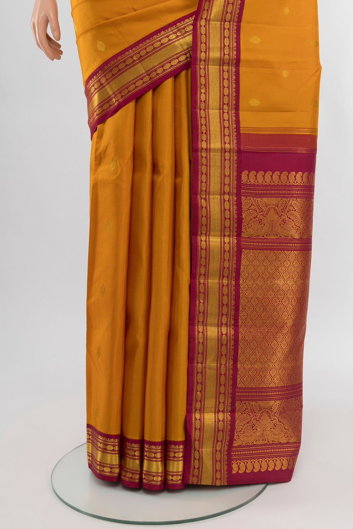 Pleats and pallu of Mustard Kanchipuram Silk Saree with Zari Butta on the body and Zari Border. 