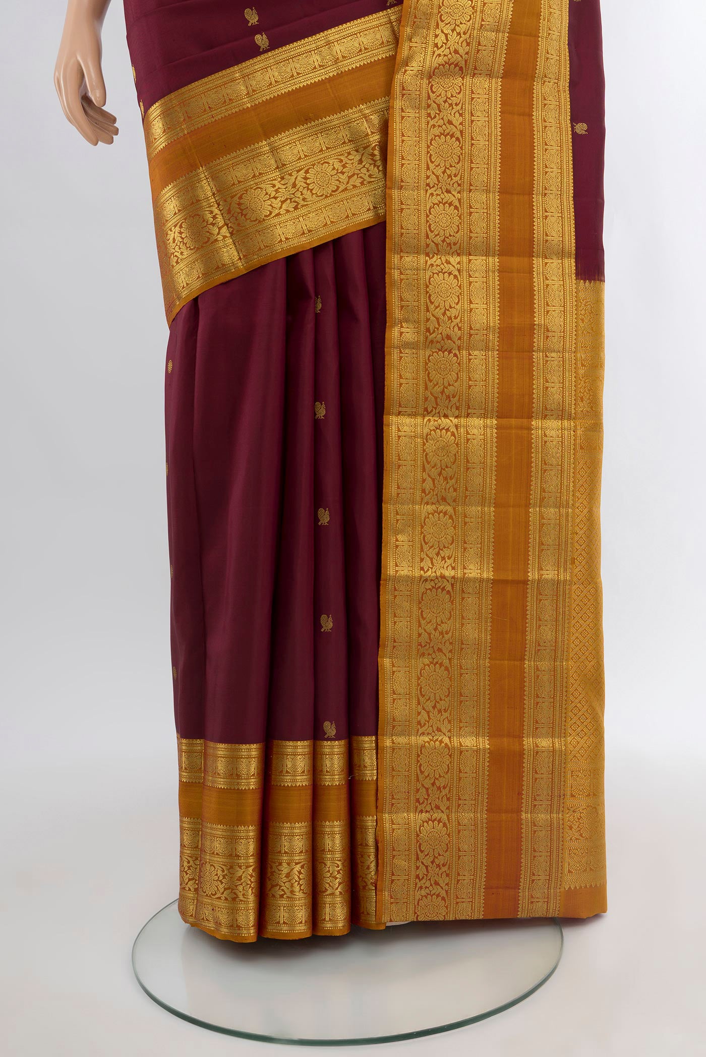 Pleats and pallu of Maroon Kanchipuram Silk Saree with Zari Butta on the body and Zari Border. 