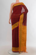 Maroon Silk Cotton Saree with Zari Butta on the body and Silk Border.  displayed on a mannequin