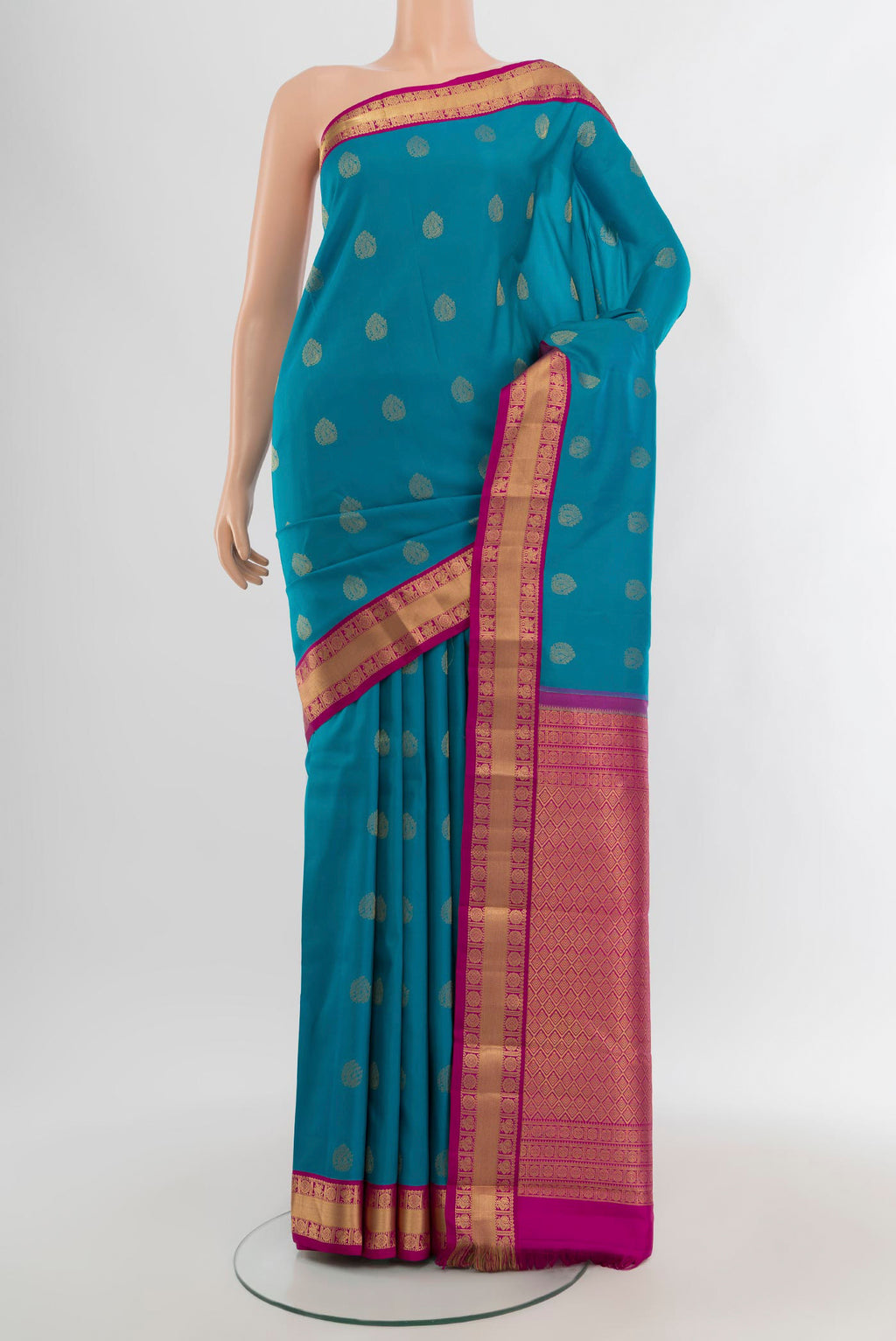 Peacock Blue Kanchipuram Silk Saree with Zari Butta on the body and Zari Border.  displayed on a mannequin