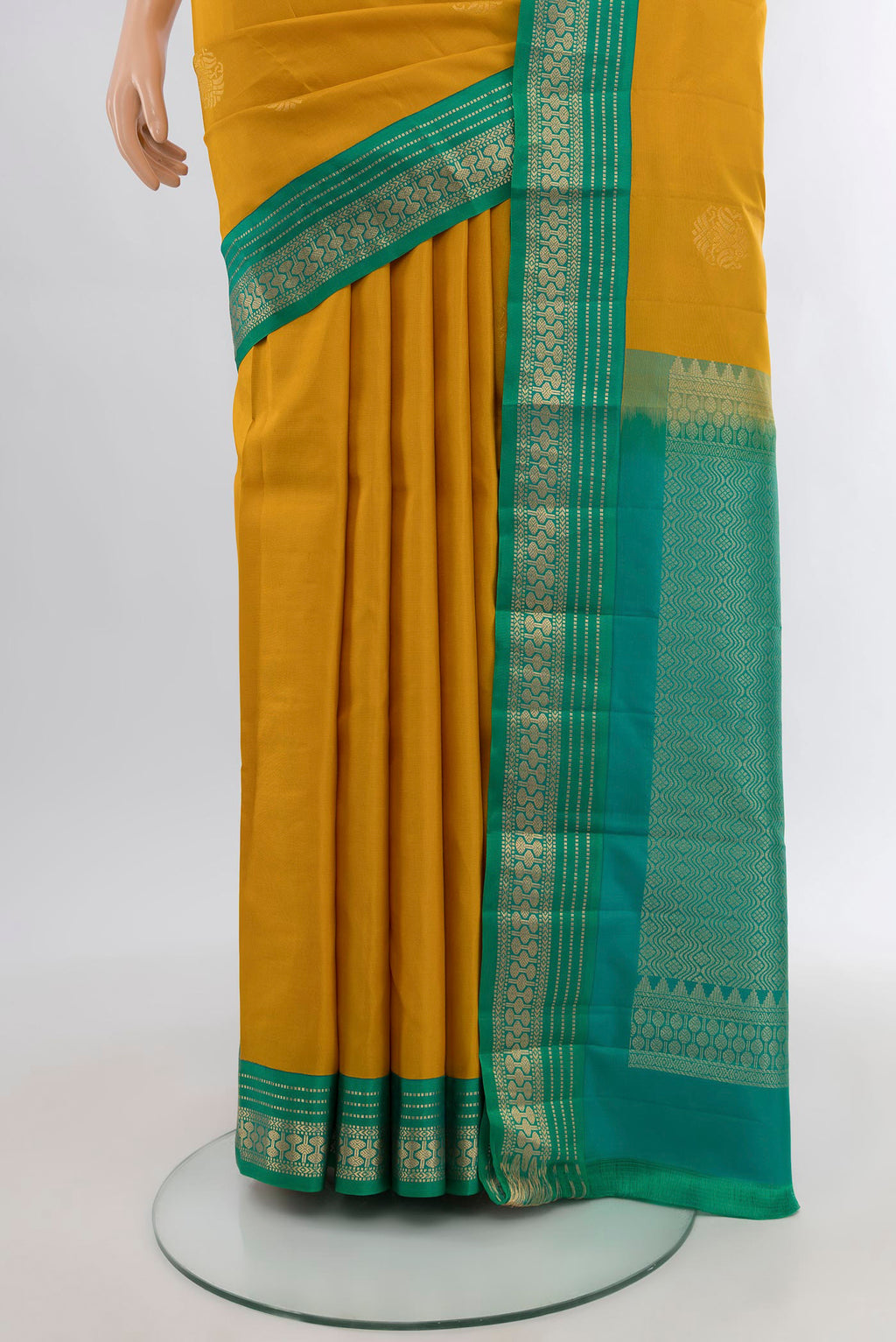 Pleats and pallu of Mustard Kanchipuram Silk Saree with Zari Butta on the body and Zari Border. 