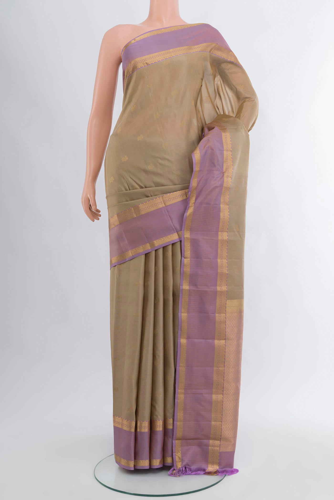 Beige Kanchipuram Silk Saree with Zari Butta on the body and Zari Border.  displayed on a mannequin