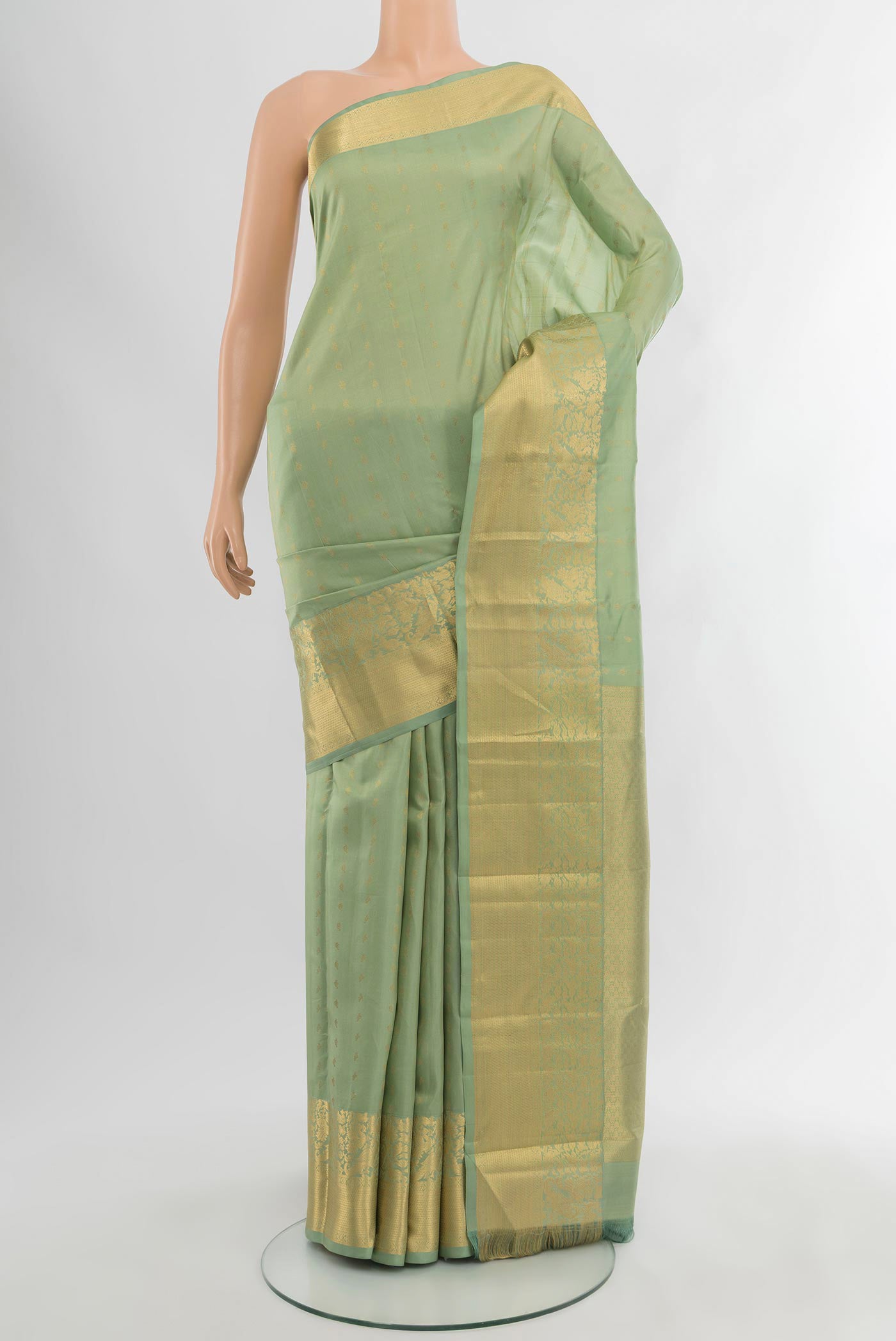 Light Green Kanchipuram Silk Saree with Zari Butta on the body and Zari Border.  displayed on a mannequin