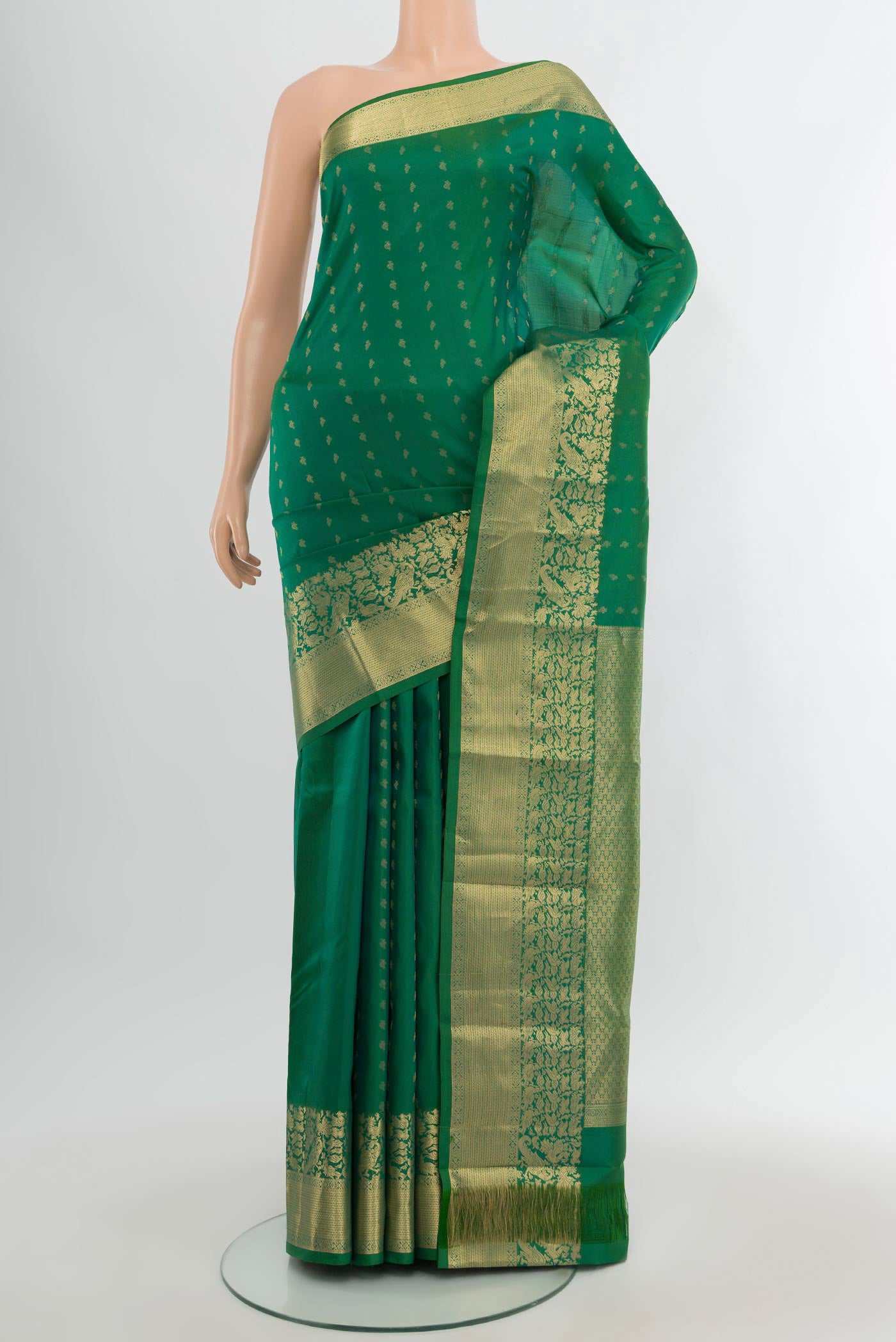 Green Kanchipuram Silk Saree with Zari Butta on the body and Zari Border.  displayed on a mannequin