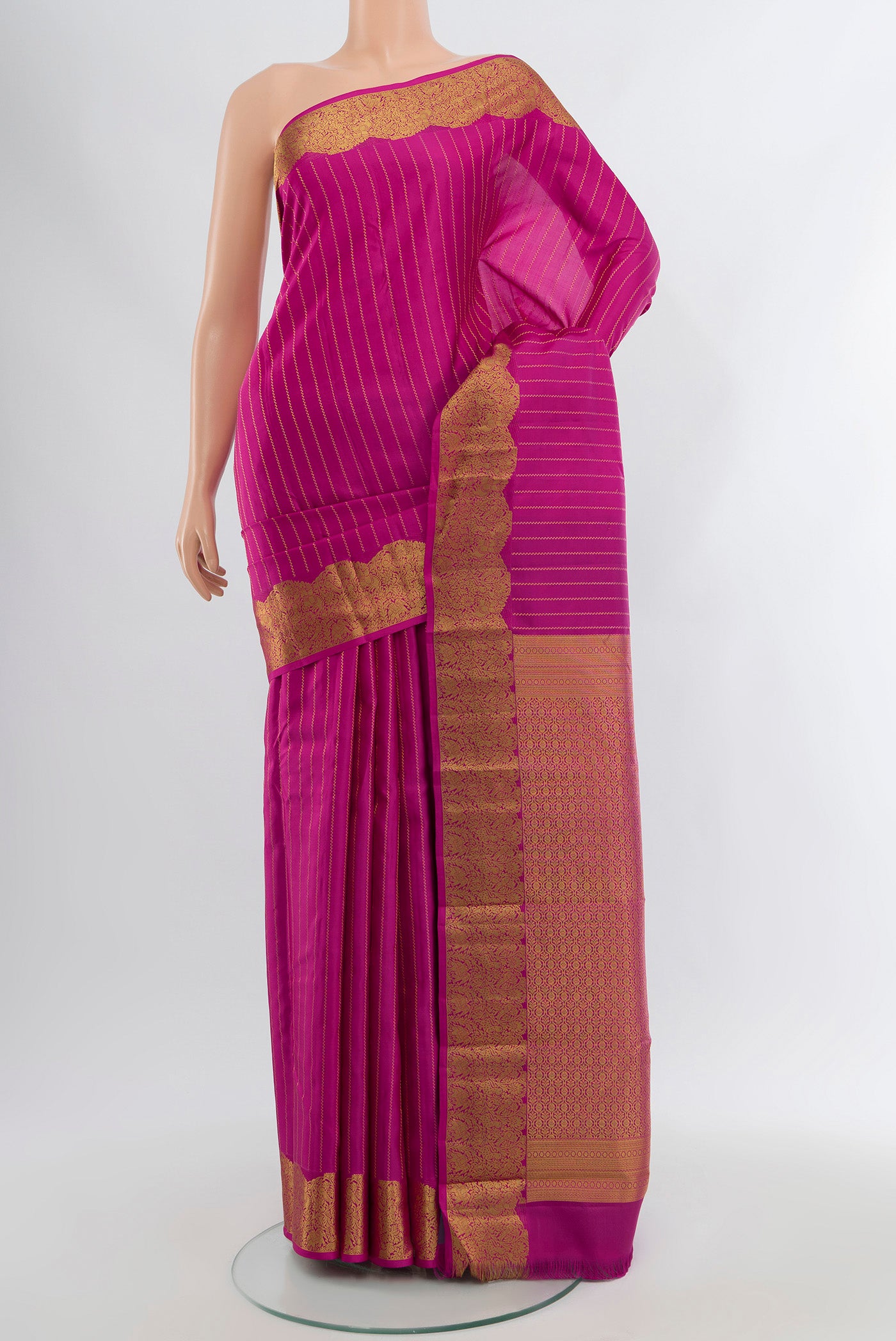 Rani Pink Kanchipuram Silk Saree with Stripes on the body and Zari Border.  displayed on a mannequin