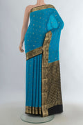 Light Blue Mysore Crepe Saree with Zari Butta on the body and Zari Border.  displayed on a mannequin