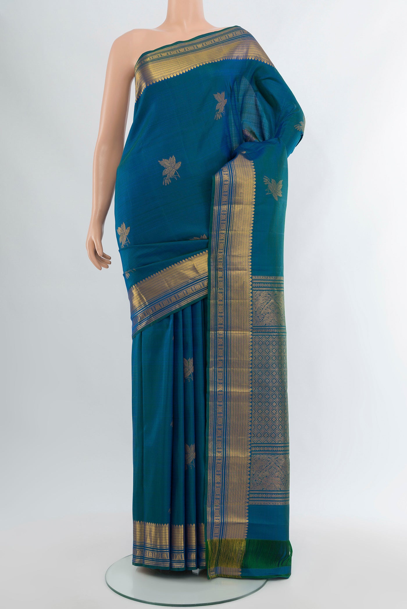 Peacock Blue Kanchipuram Silk Saree with Zari Butta on the body and Zari Border.  displayed on a mannequin