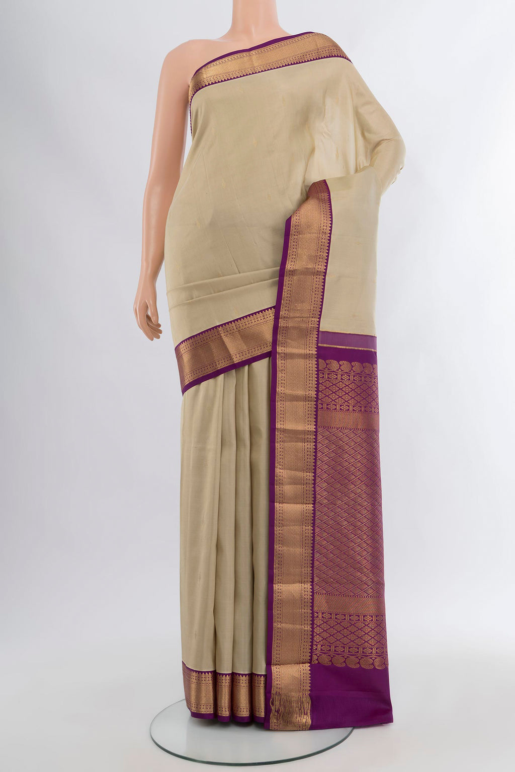 Beige Kanchipuram Silk Saree with Zari Butta on the body and Zari Border.  displayed on a mannequin