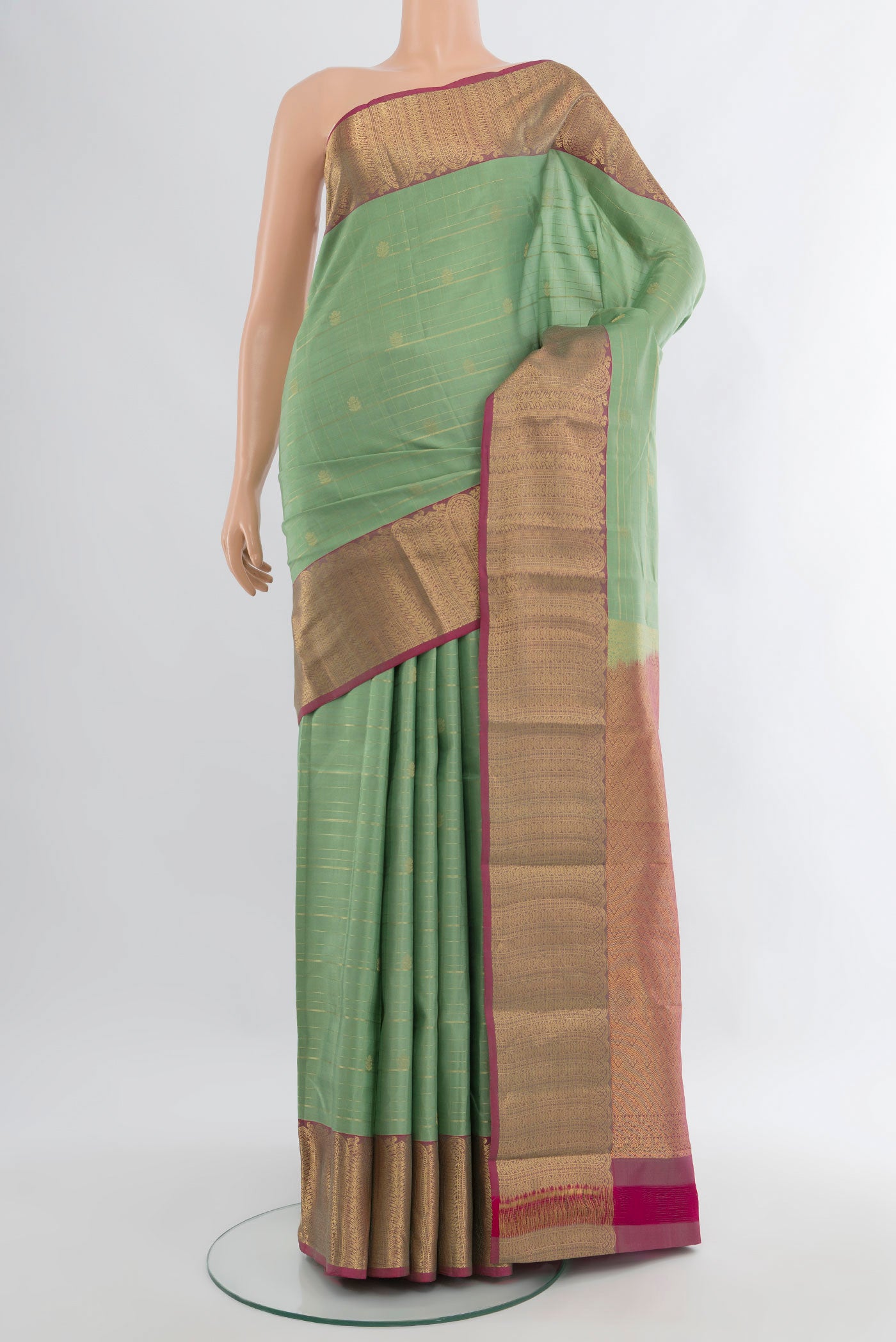 Pista Green Kanjivaram Silk Saree with Zari Butta on the body and Zari Border.  displayed on a mannequin