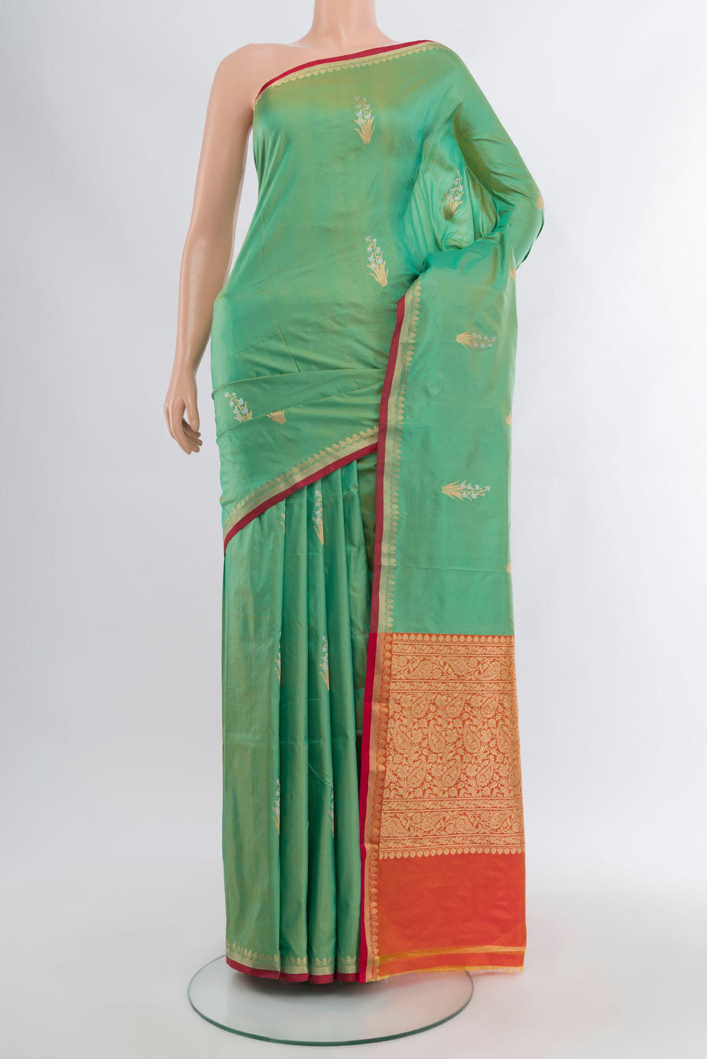 Light Green Banarasi Katan Silk Saree with Zari Butta on the body and Zari Border.  displayed on a mannequin