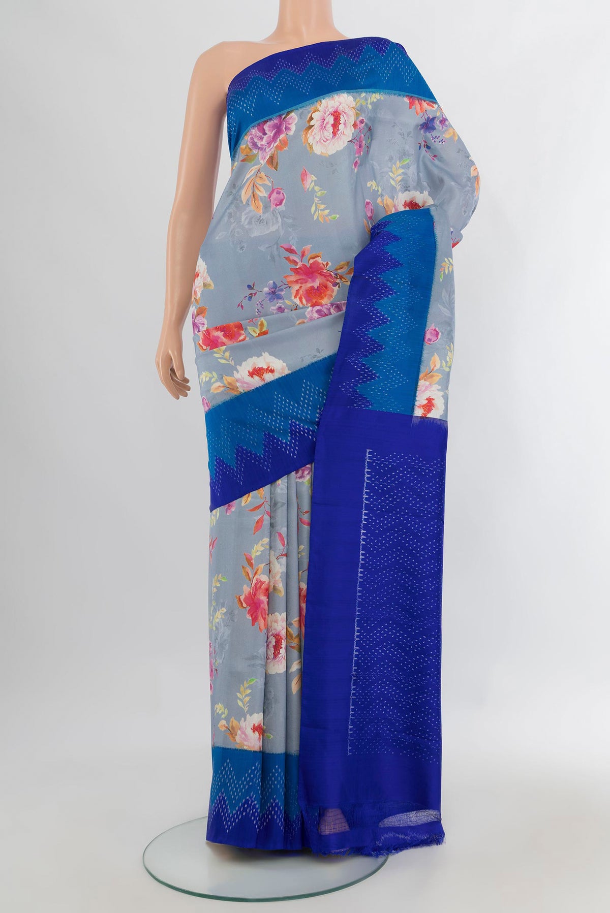 Pure Silk Light Blue Printed Saree with Floral Print on the body and Ikat Border.  displayed on a mannequin