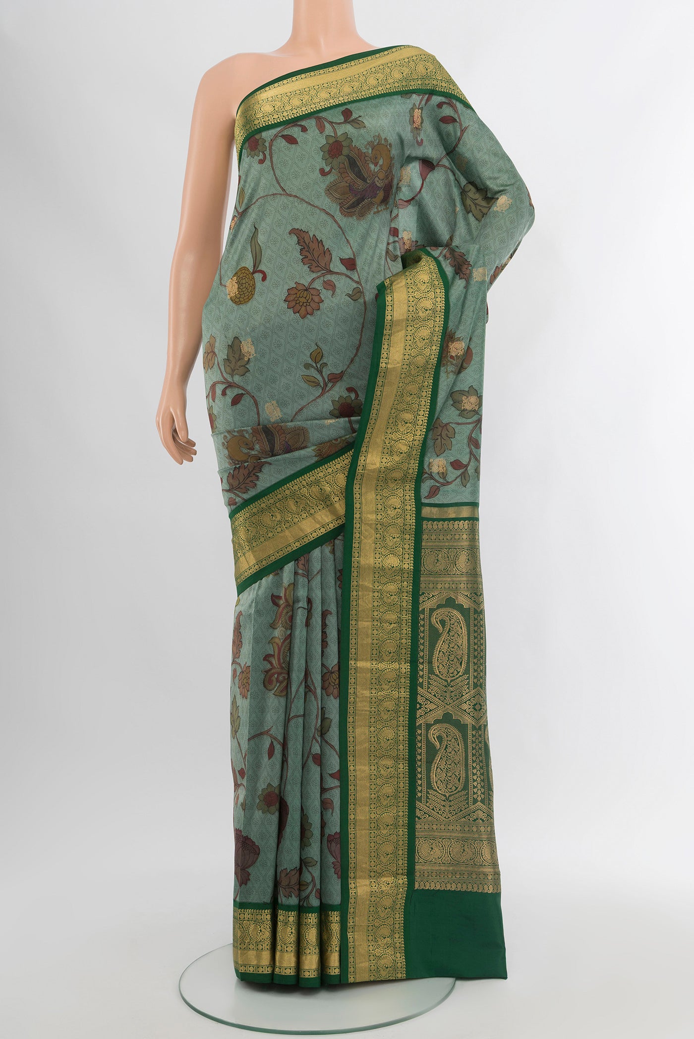 Green Printed Silk Saree with Floral Print on the body and Zari Border.  displayed on a mannequin