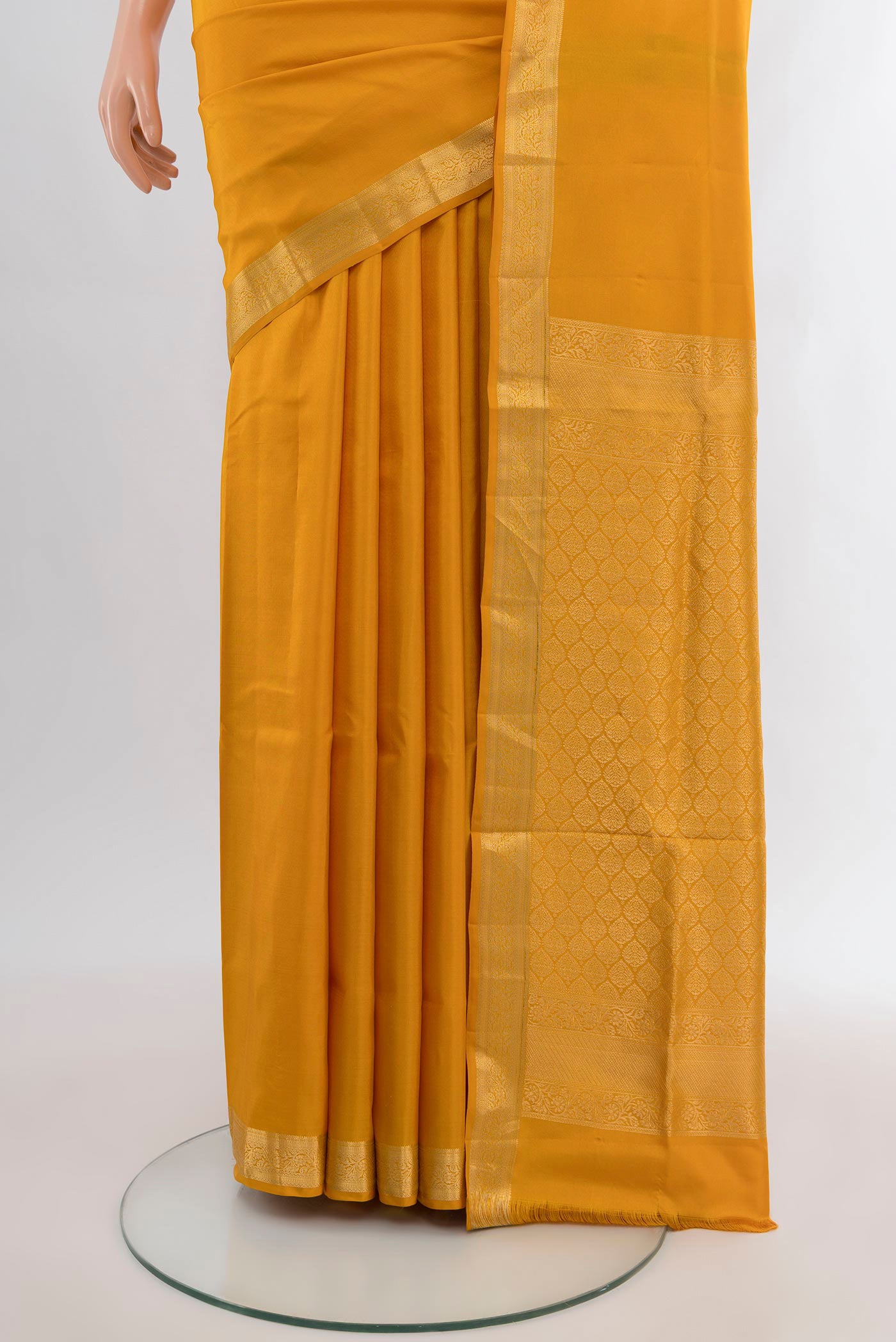 Pleats and pallu of Mustard Soft Silk Saree with Plain Body and Zari Border. 