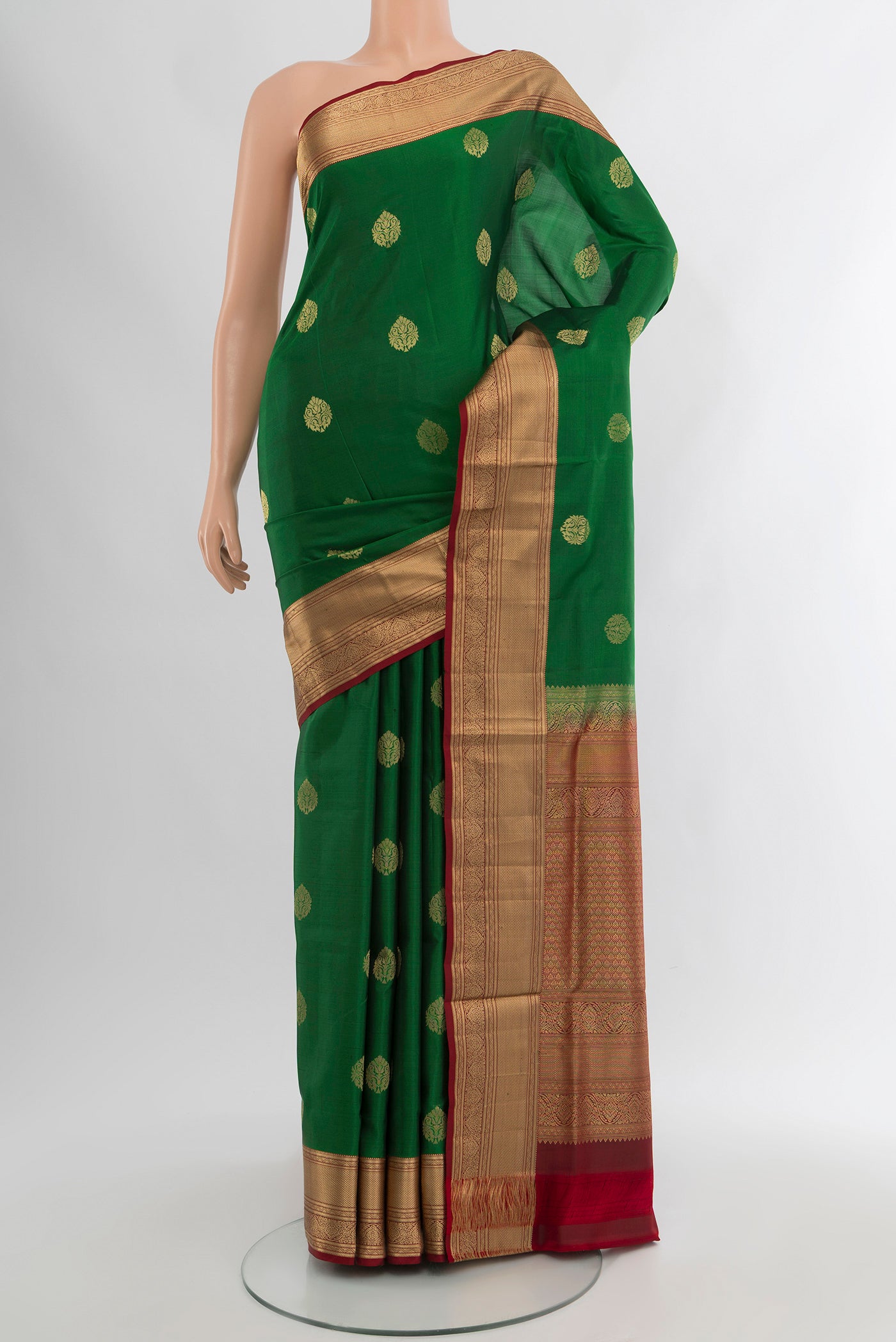 Green Soft Silk Saree with Zari Butta on the body and Zari Border.  displayed on a mannequin