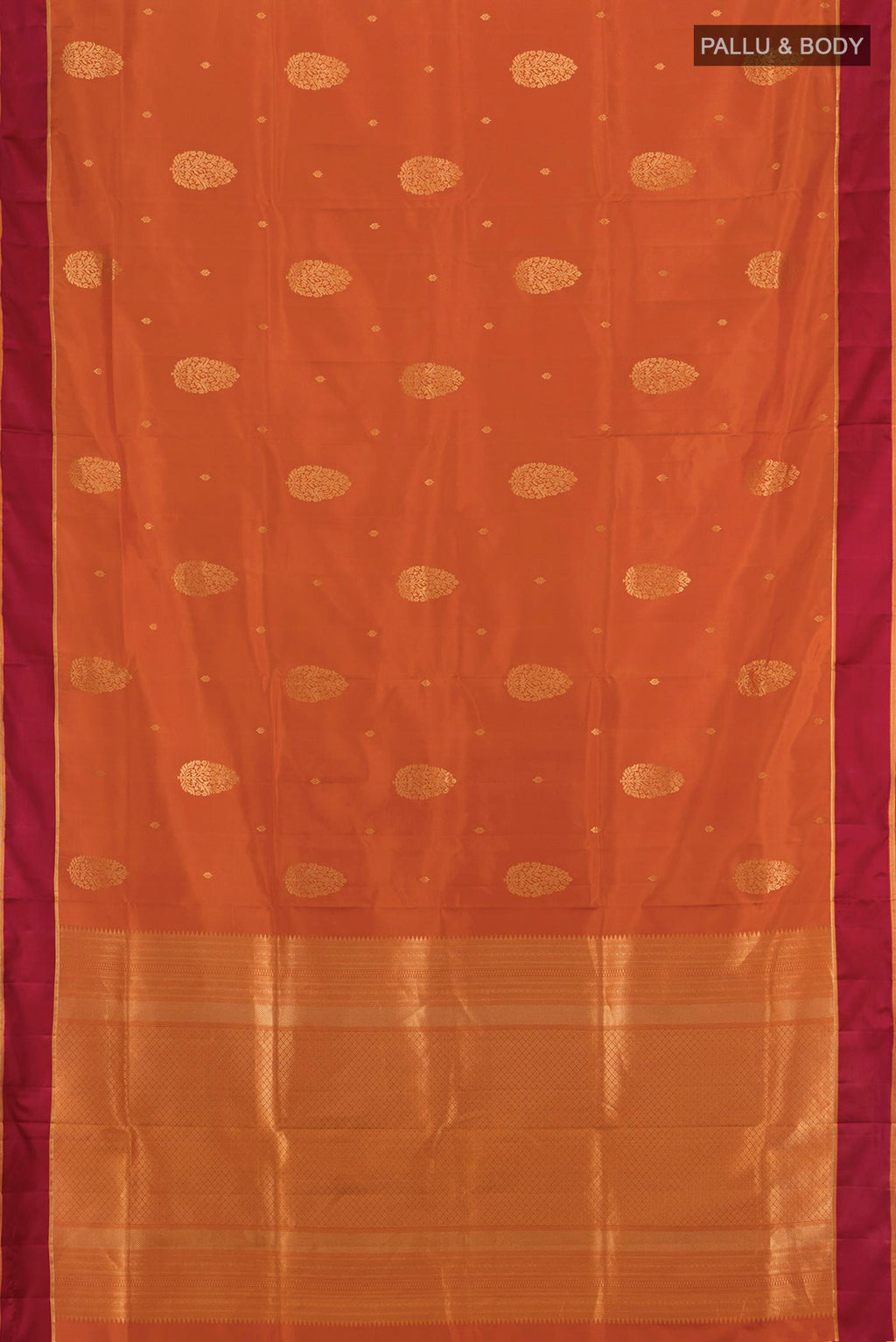 Flat view of Rust Soft Silk Saree with Zari Butta on the body and Temple Border. 