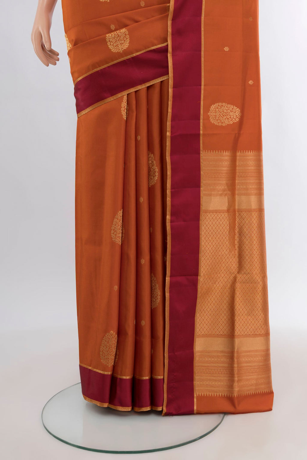 Pleats and pallu of Rust Soft Silk Saree with Zari Butta on the body and Temple Border. 