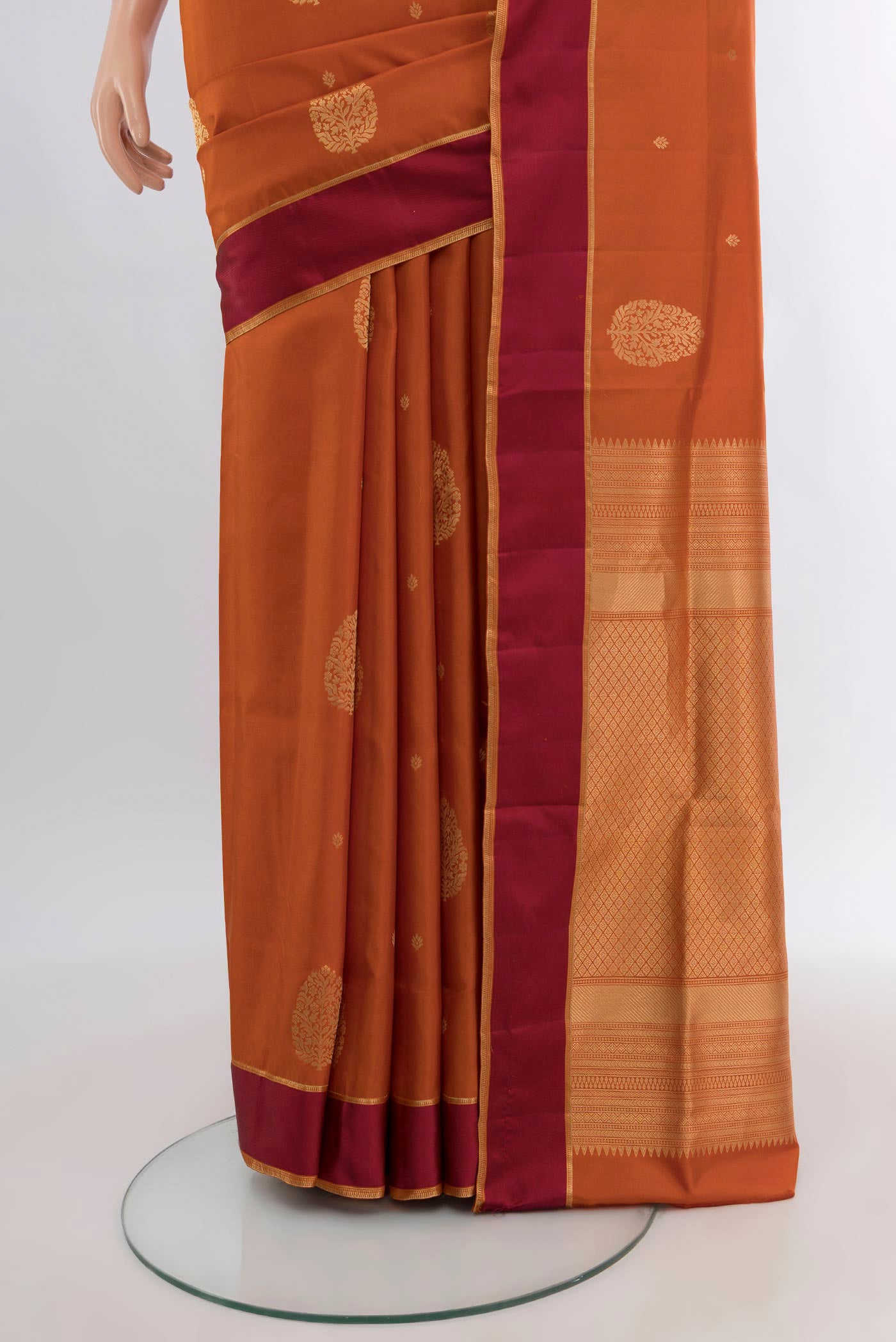 Pleats and pallu of Rust Soft Silk Saree with Zari Butta on the body and Temple Border. 