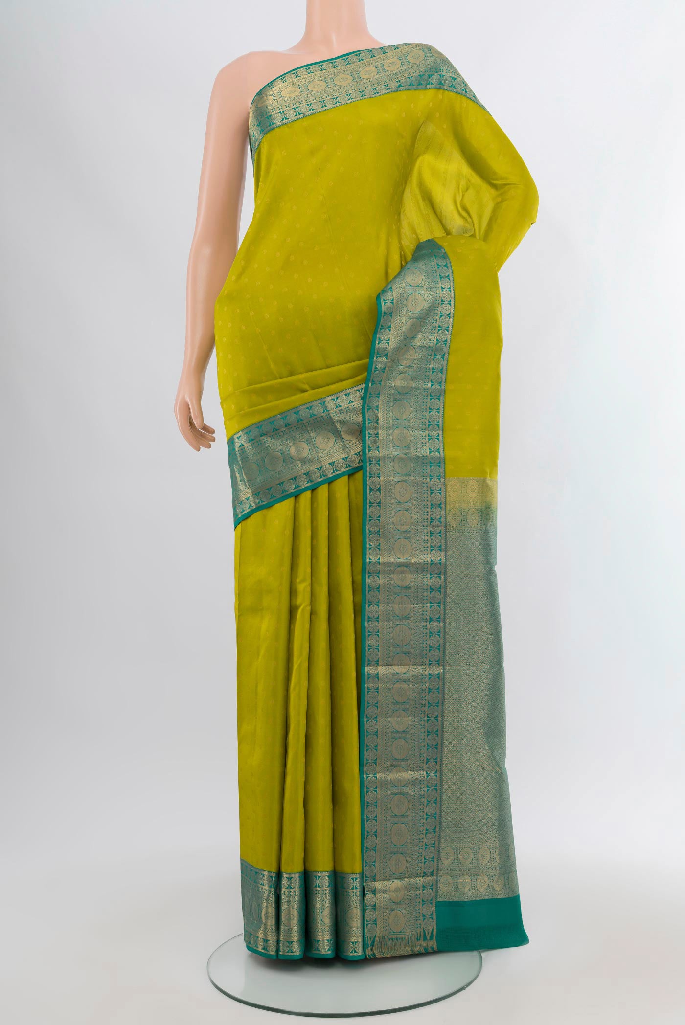 Parrot Green Kanchipuram Silk Saree with Zari Butta on the body and Zari Border.  displayed on a mannequin