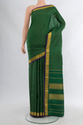 Bottle Green Kanchipuram Silk Saree with Plain Body and Zari Border.  displayed on a mannequin