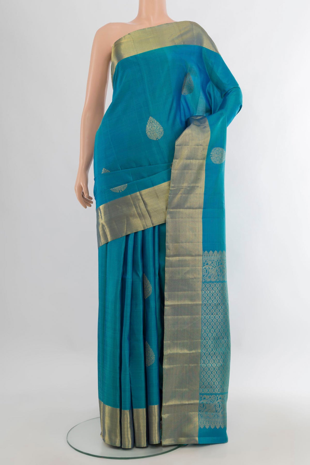 Pure Silk Peacock Blue Kanchipuram Saree with Zari Butta on the body and Zari Border.  displayed on a mannequin