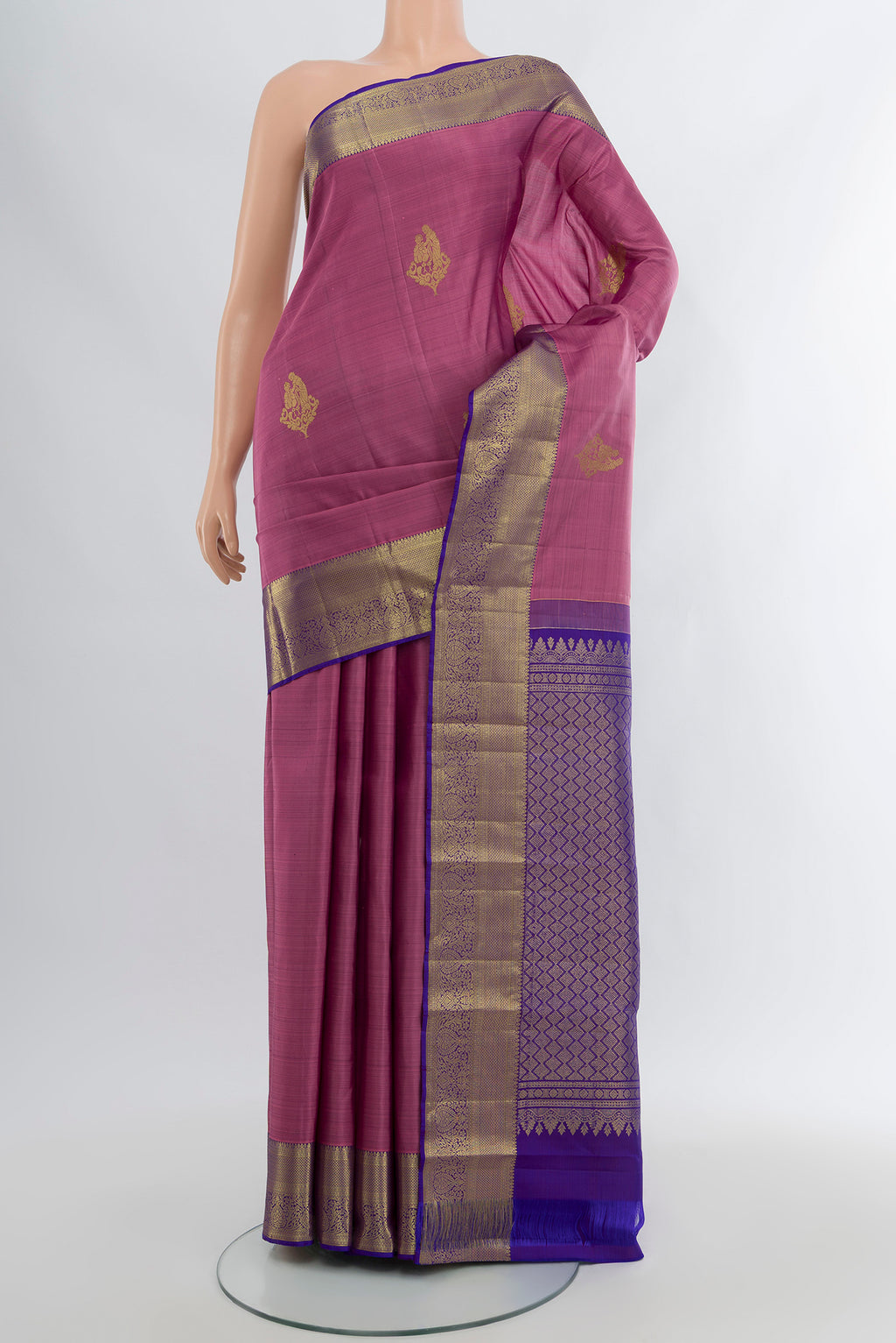 Mauve Kanchipuram Silk Saree with Zari Butta on the body and Zari Border.  displayed on a mannequin