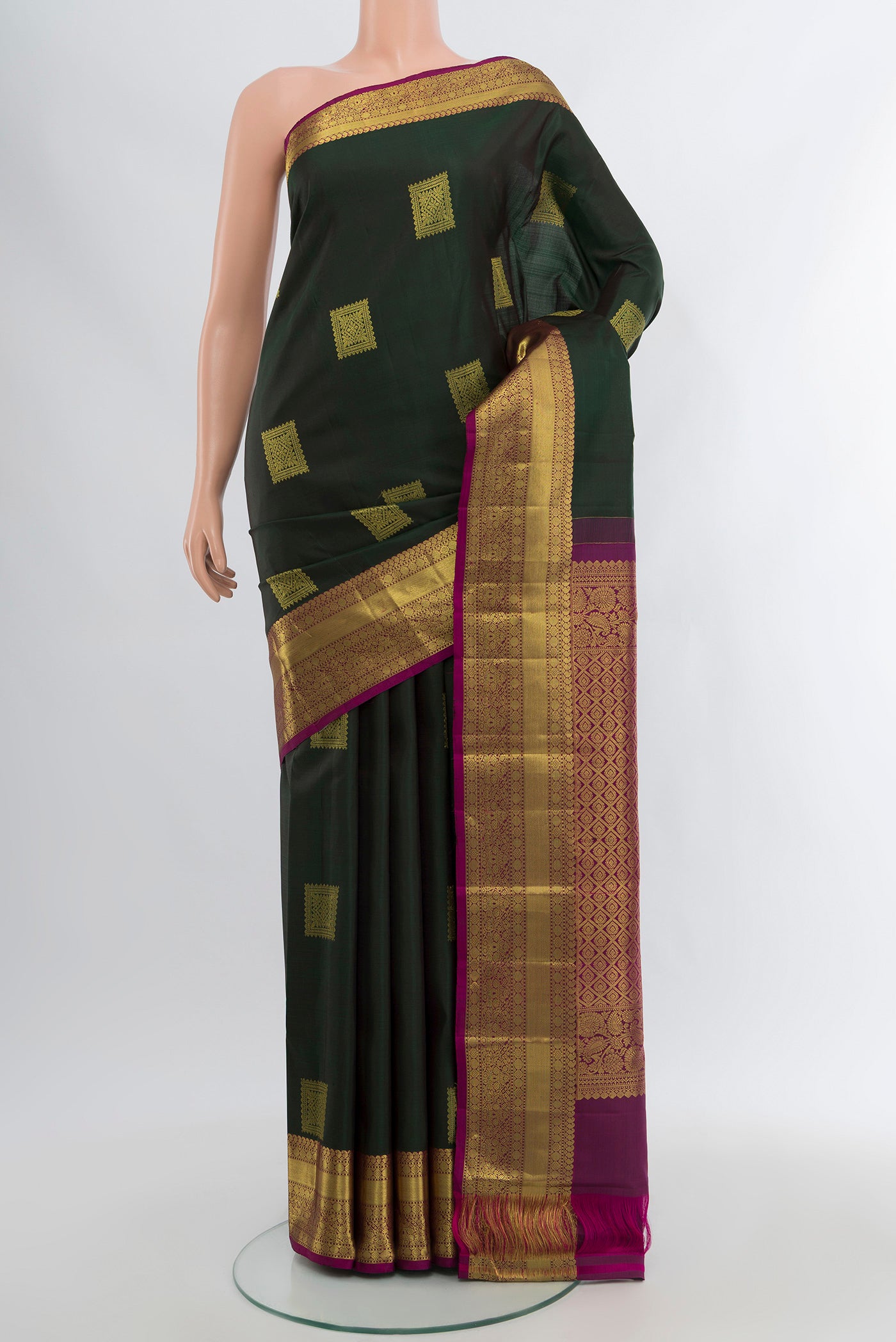 Bottle Green Kanchipuram Silk Saree with Zari Butta on the body and Zari Border.  displayed on a mannequin