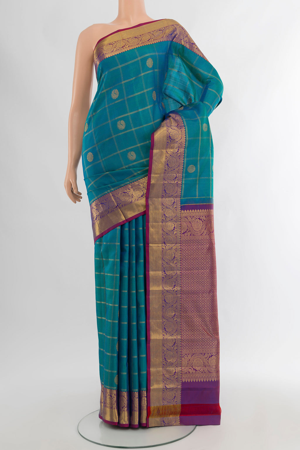 Peacock Blue Kanchipuram Silk Saree with Checked design on the body and Zari Border.  displayed on a mannequin