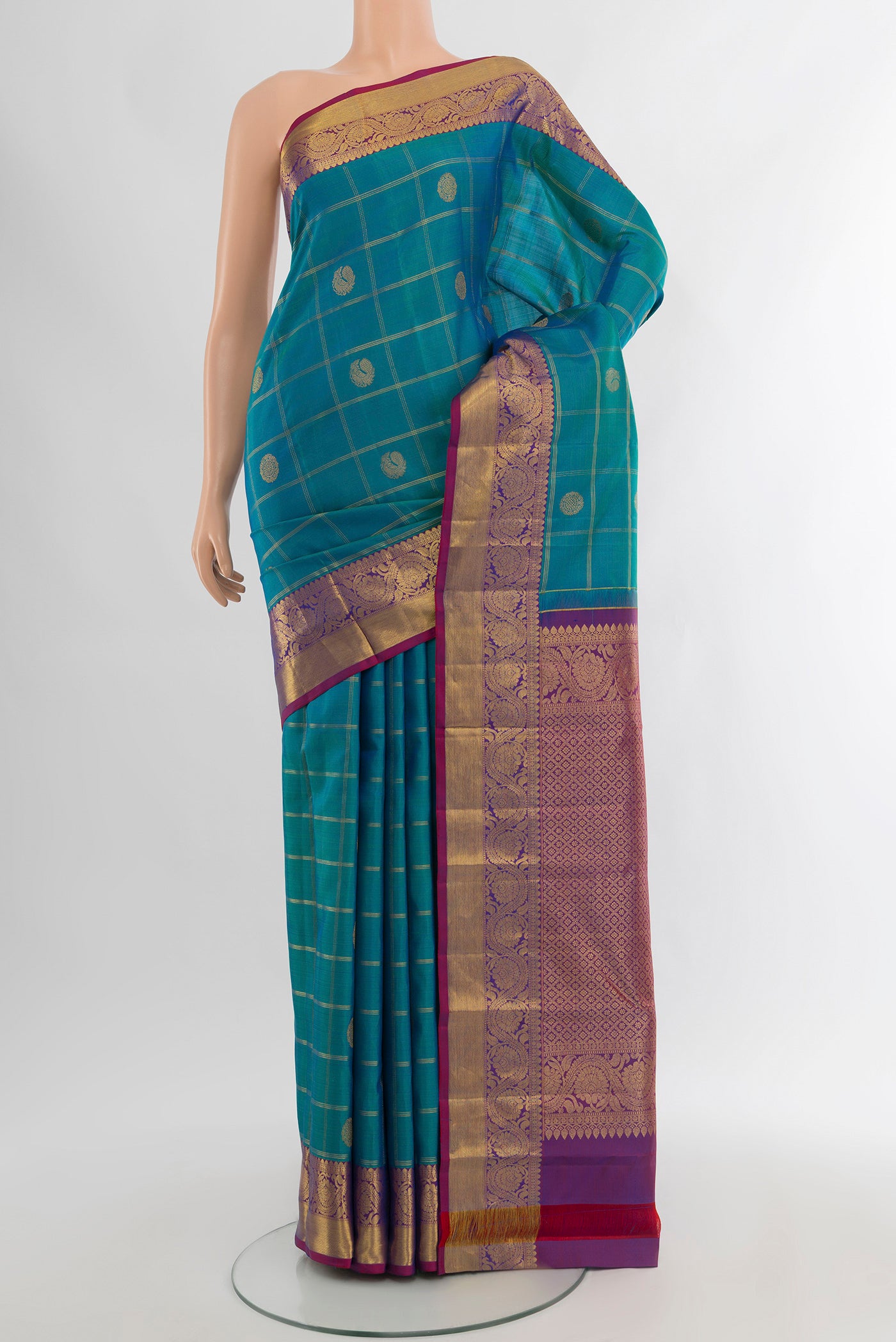 Peacock Blue Kanchipuram Silk Saree with Checked design on the body and Zari Border.  displayed on a mannequin