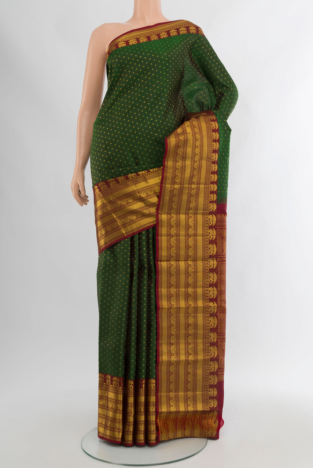 Bottle Green Kanchipuram Silk Saree with Zari Butta on the body and Zari Border.  displayed on a mannequin